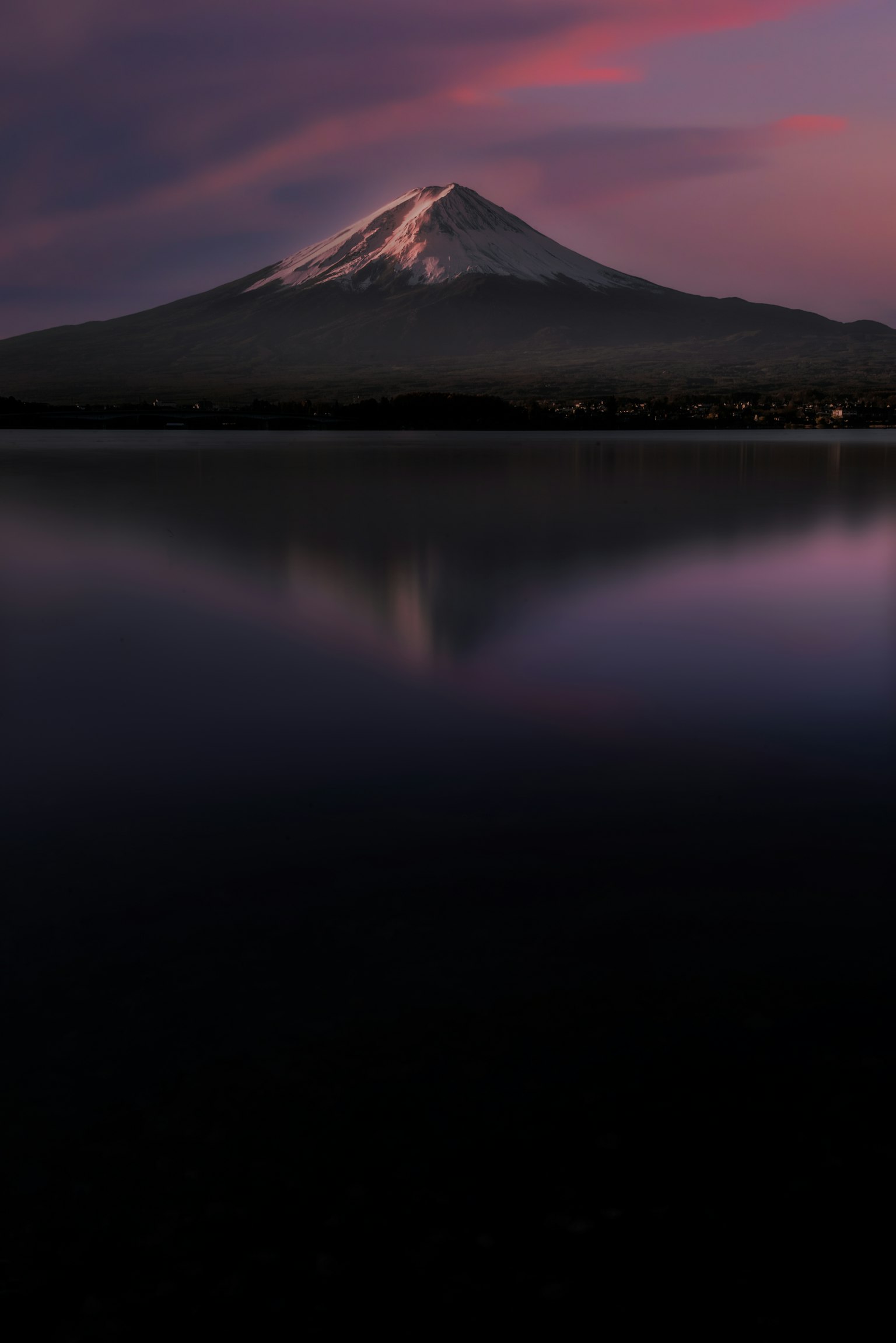 Mount Fuji illuminated by sunset reflecting in the lake