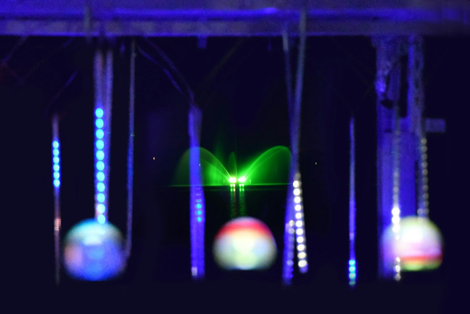 Esferas y tiras brillantes de colores suspendidas sobre un fondo oscuro