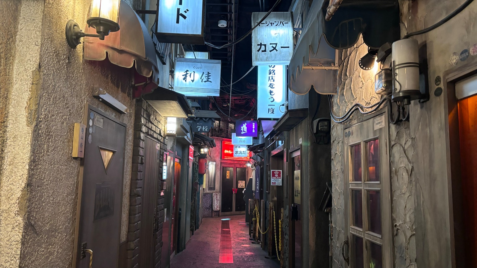 Schmale Gasse mit Restaurant-Schildern und Türen