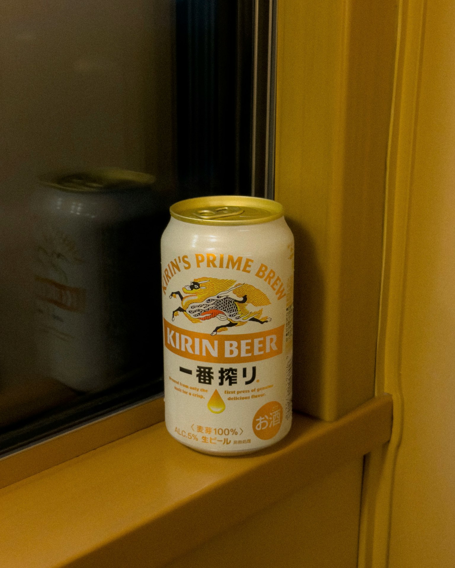 窗邊的麒麟啤酒罐和黃色牆壁