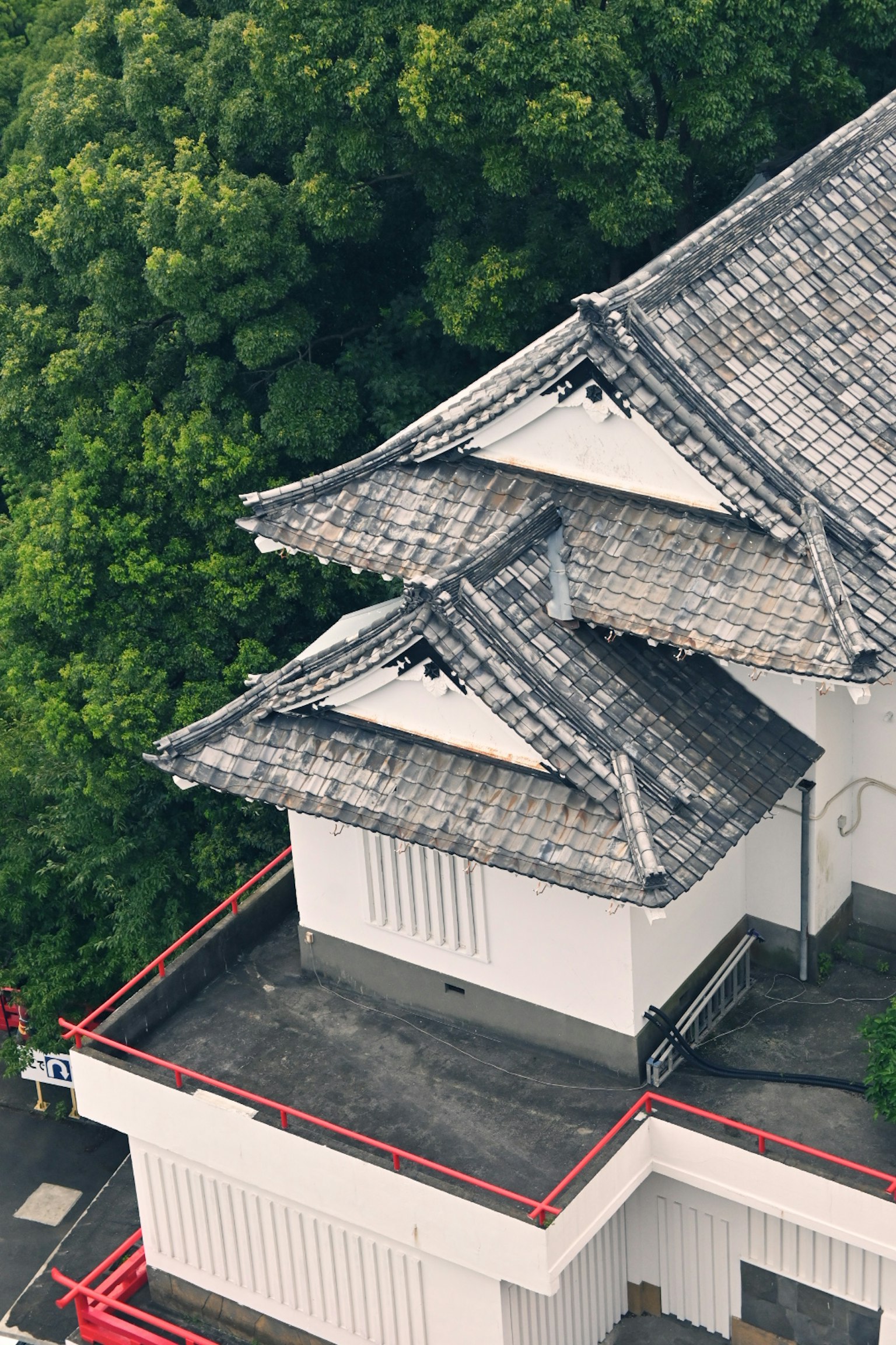 Japanese building with a beautiful roof and green background