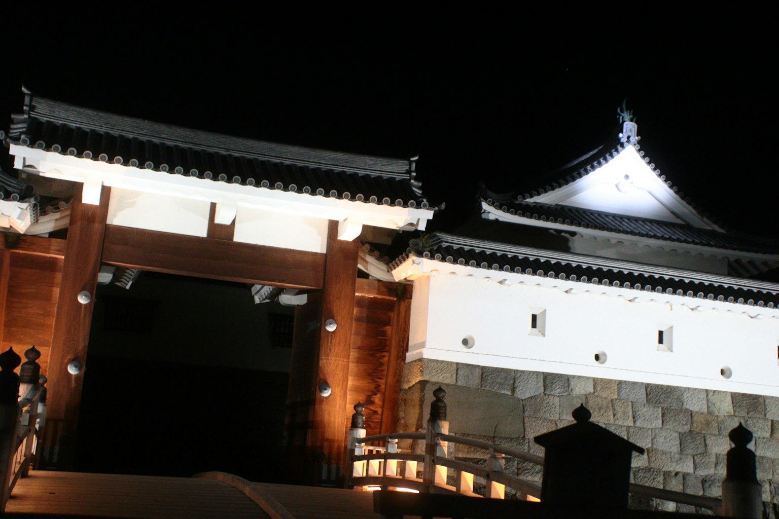 夜间照明下的传统日本城堡门和建筑