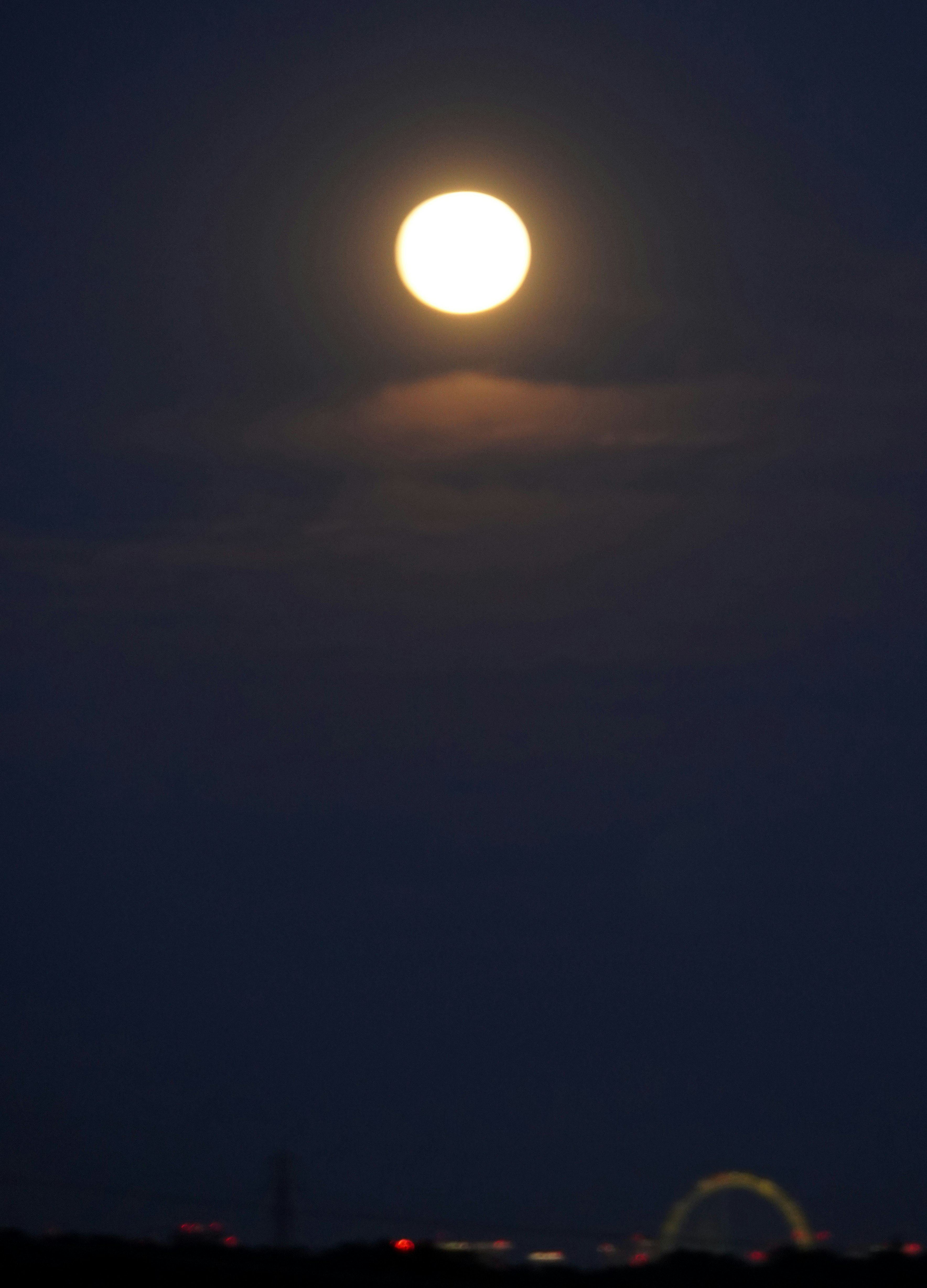 moon rising through clouds over a night sky