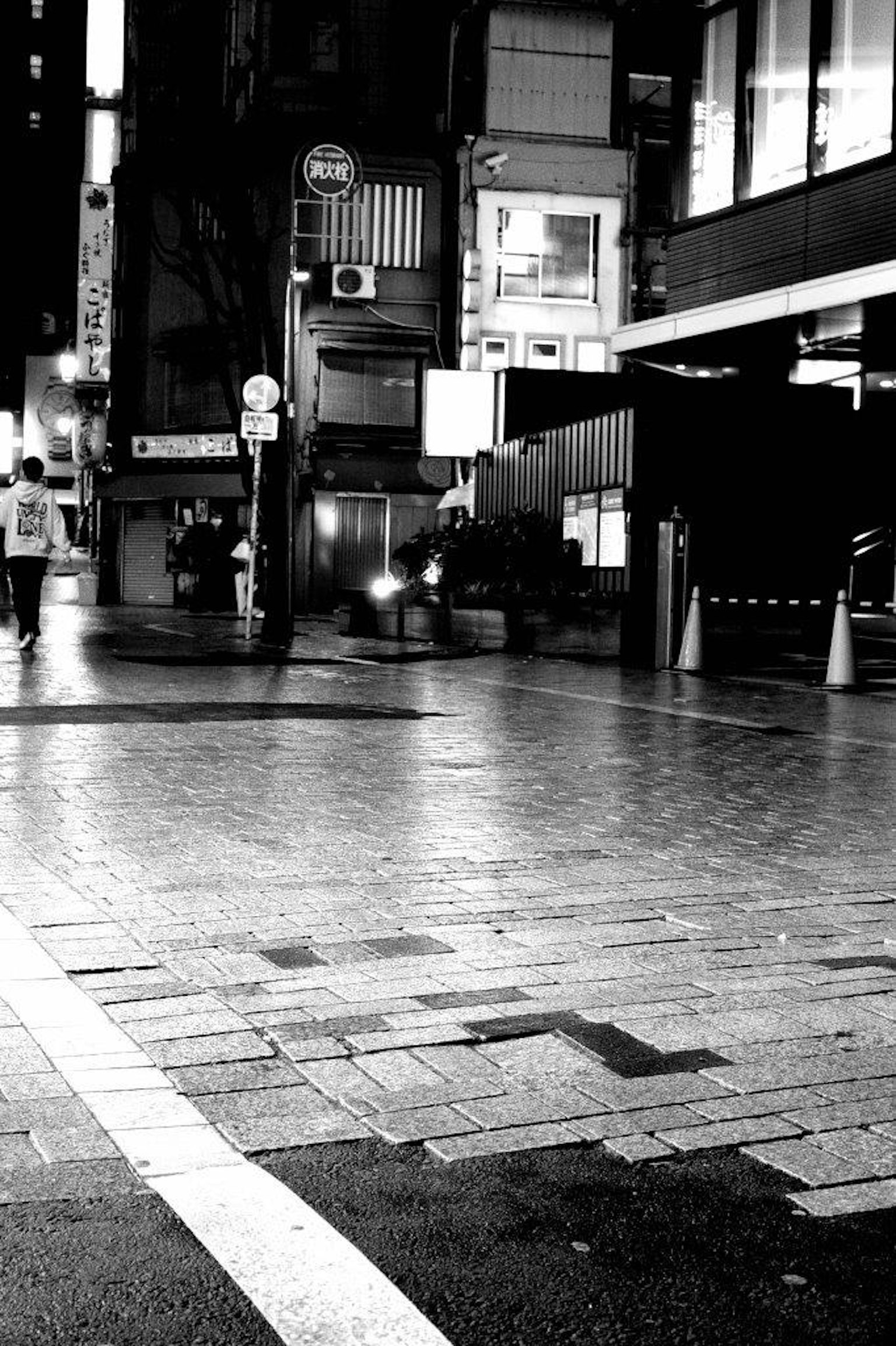 Black and white urban scene showing people walking at an intersection