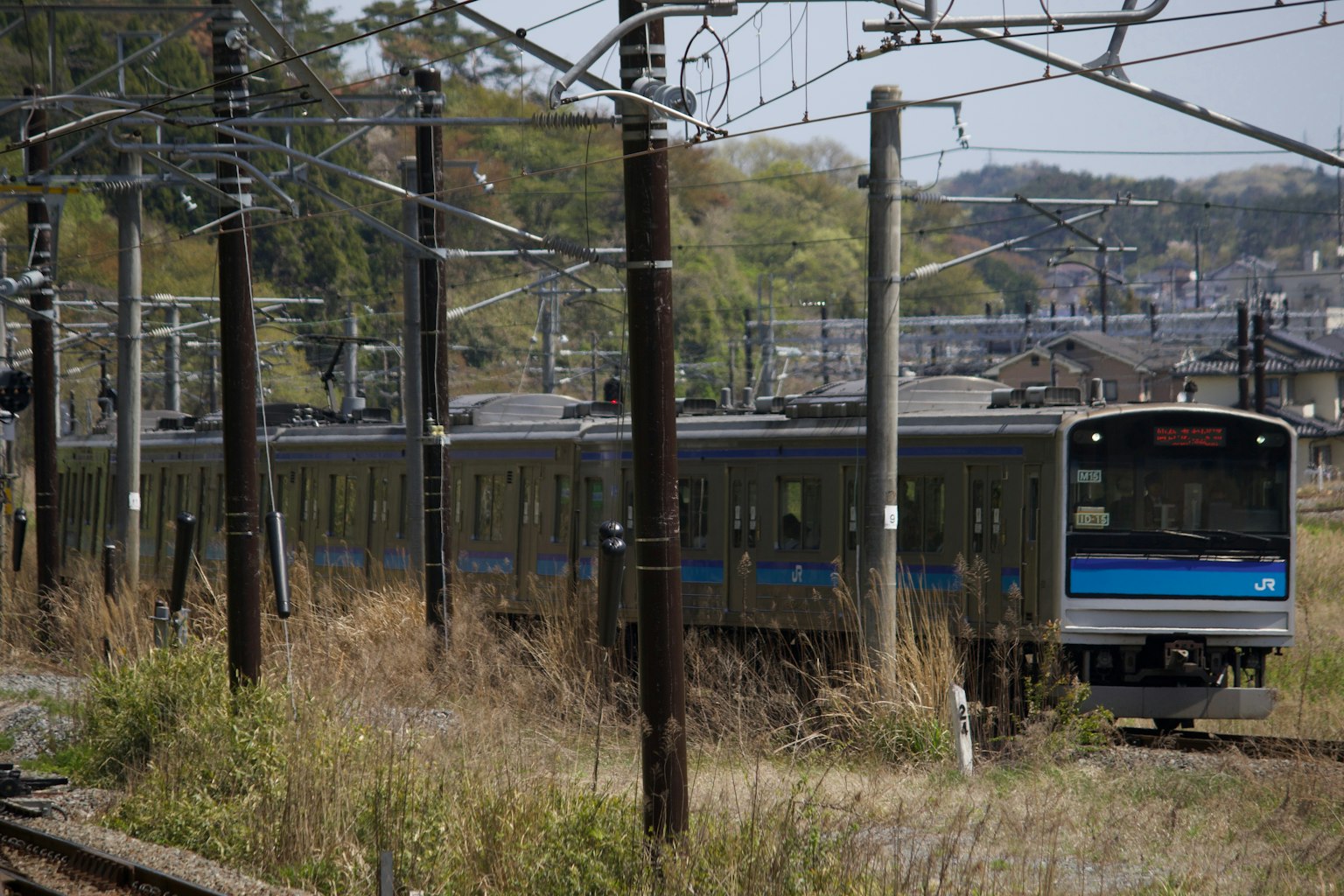 Kereta dengan garis biru melintasi padang rumput