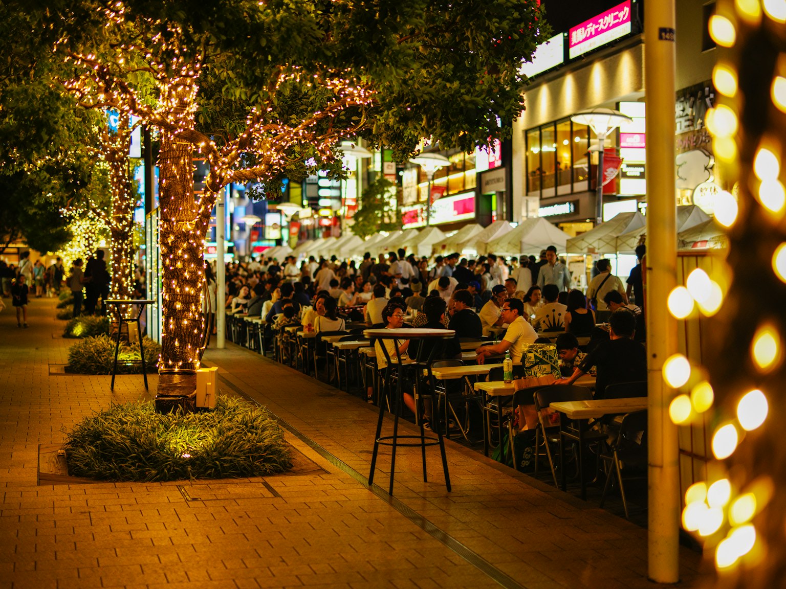 Belebter Außenbereich mit Beleuchtung in einer geschäftigen Stadt bei Nacht