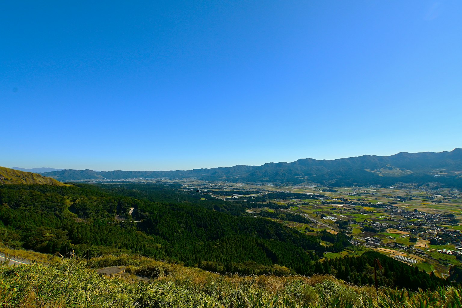 藍天之下綠色山丘的全景