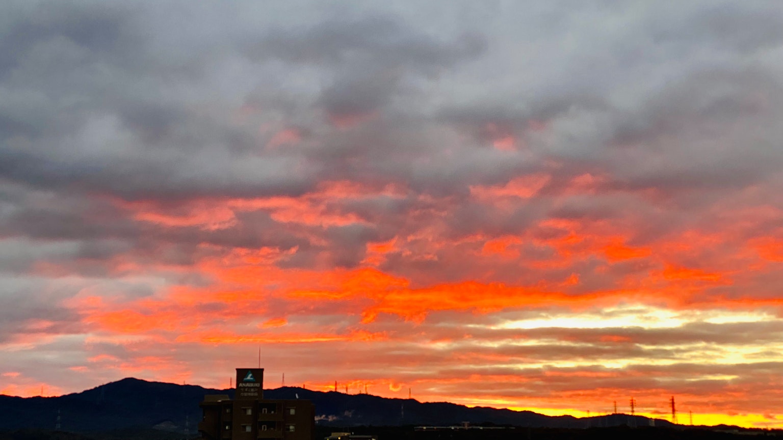 色彩斑斕的夕陽天空，背景有雲和山