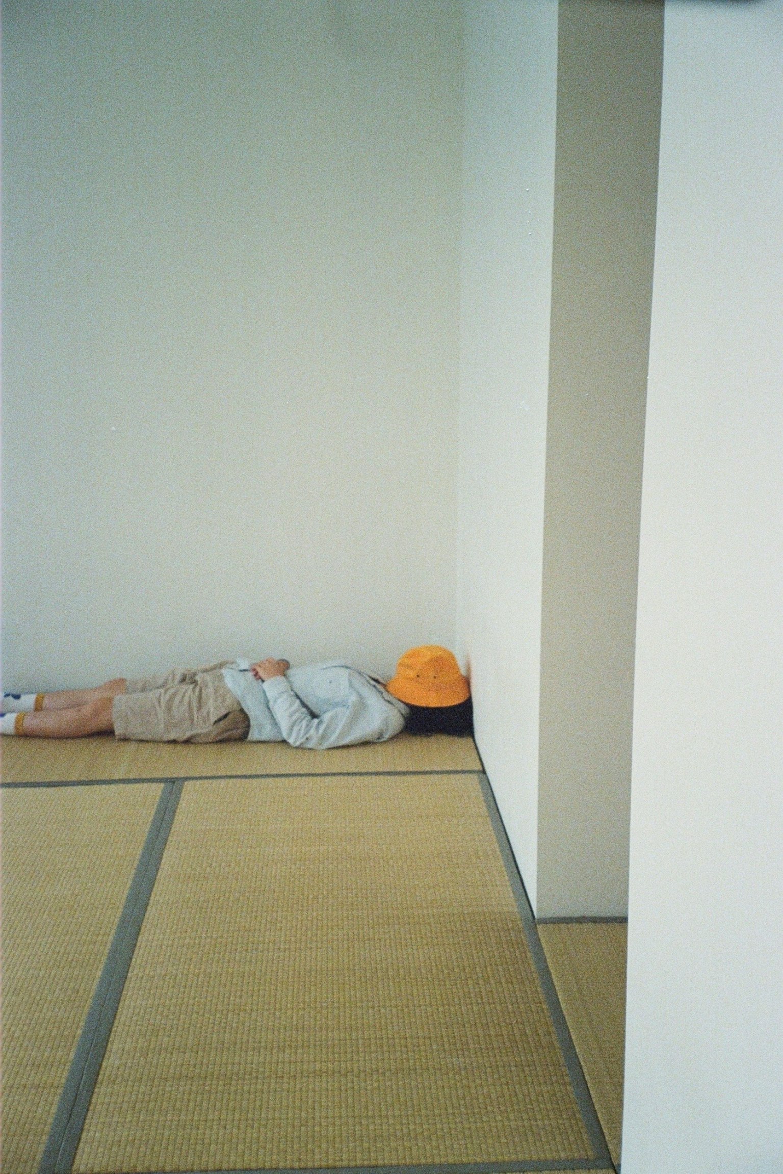 壁に寄りかかって寝ている人の姿と和室の床