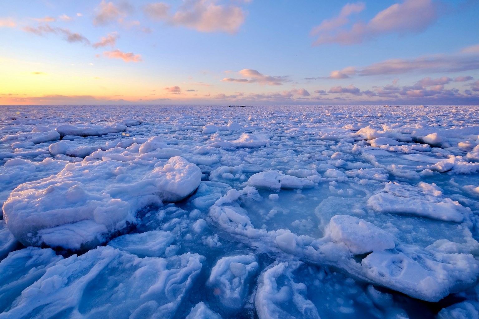 Bellissimo paesaggio di oceano di ghiaccio blu che riflette la luce del tramonto