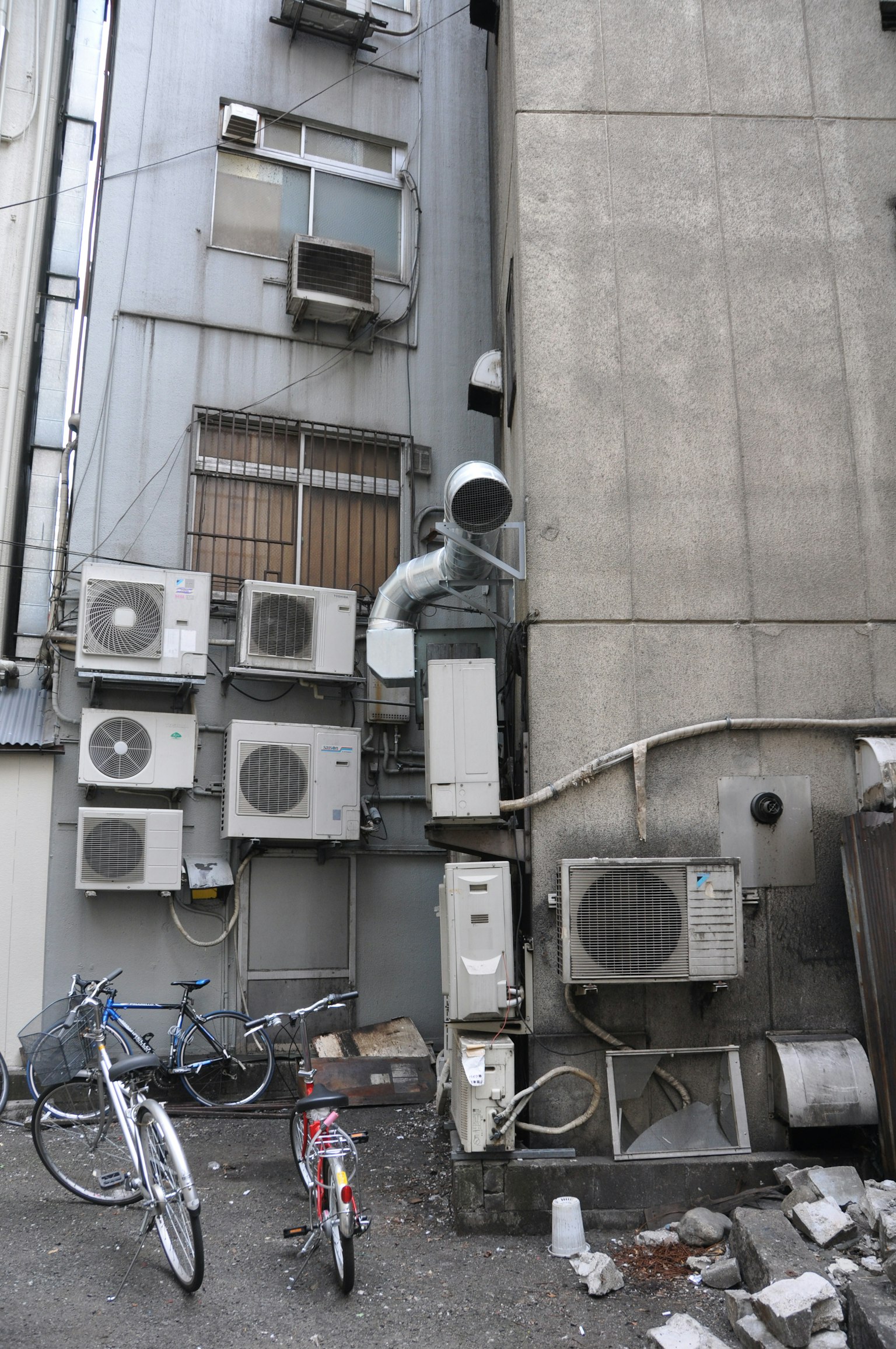 多台空調安裝在建築物側面，附近有自行車