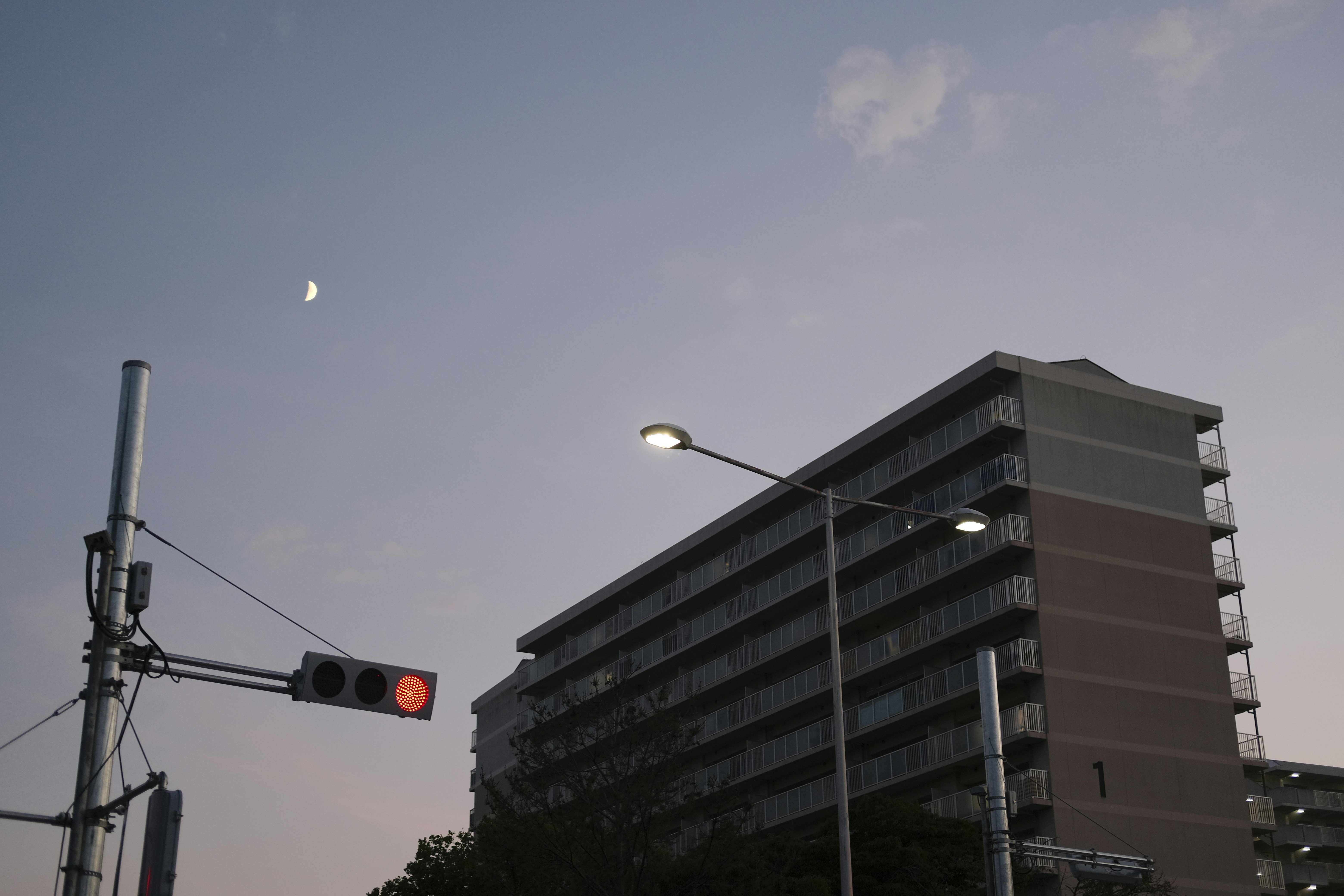 städtische Straßenecke mit Ampel und Wohnhochhaus