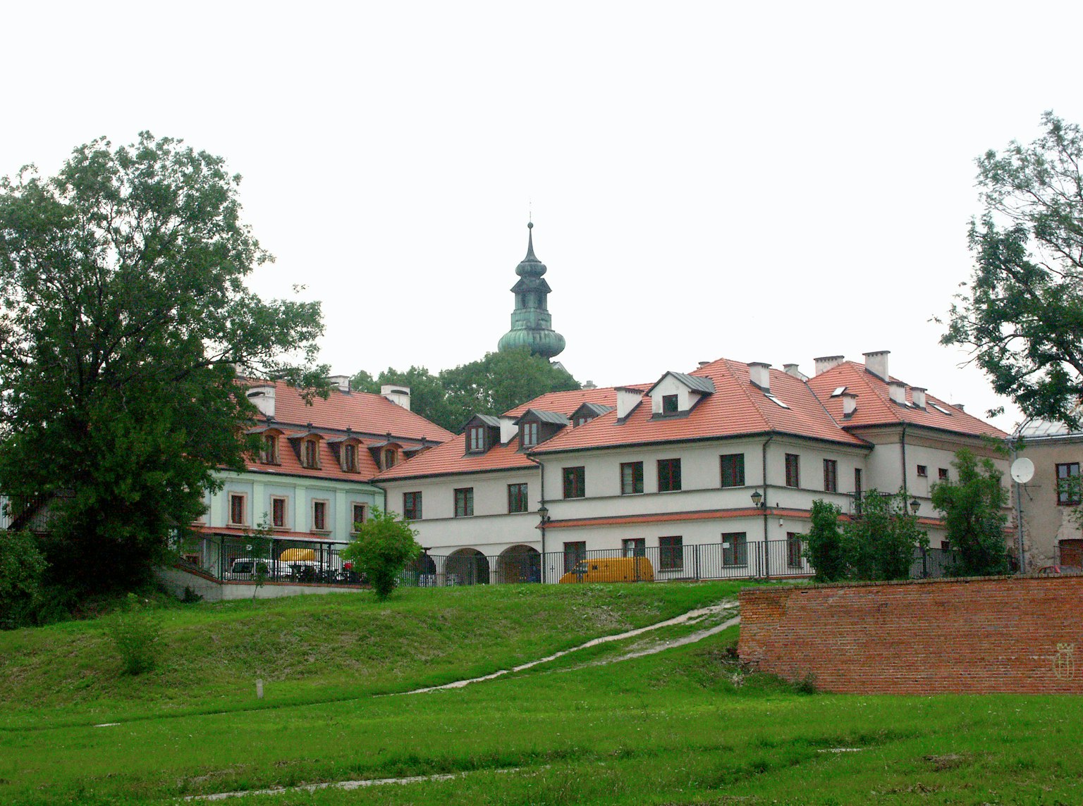 Landscape featuring a green lawn and buildings with red roofs