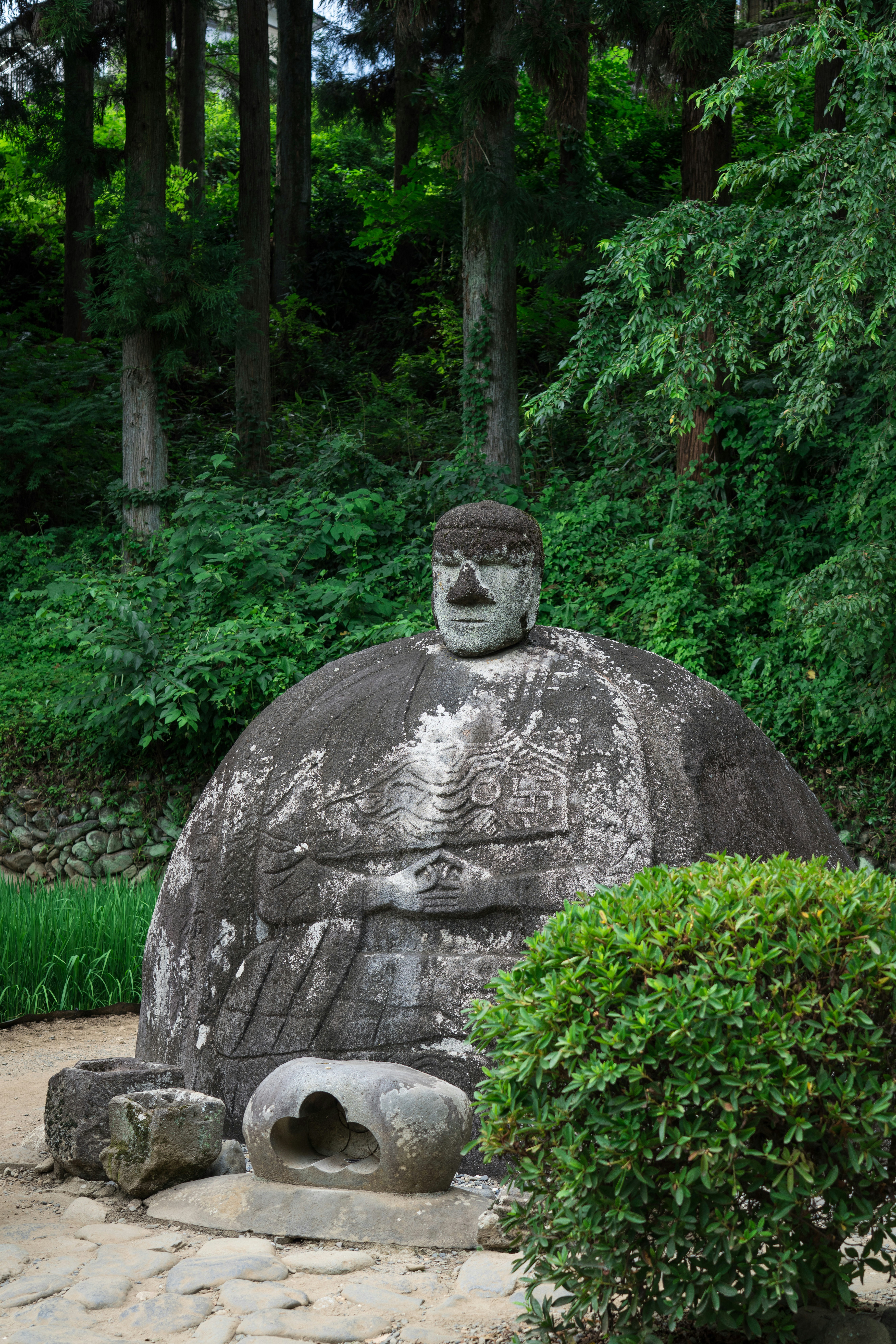 stone Buddha statue in a lush green forest