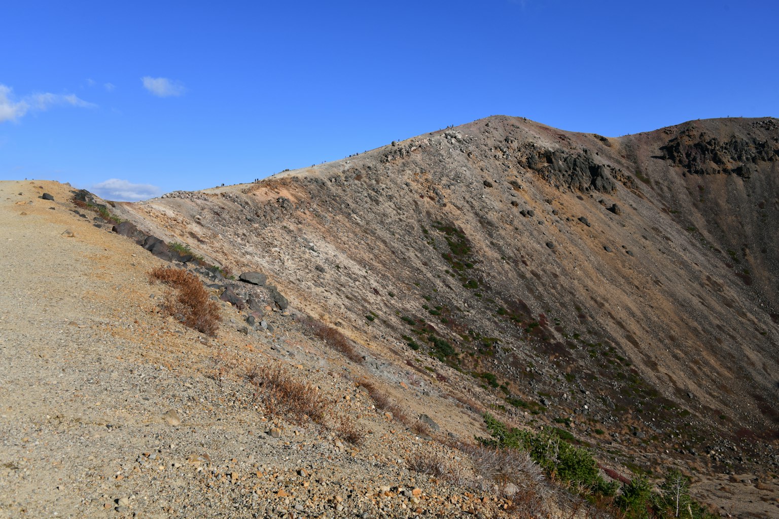 Trockene Landschaft entlang eines Berghangs unter blauem Himmel