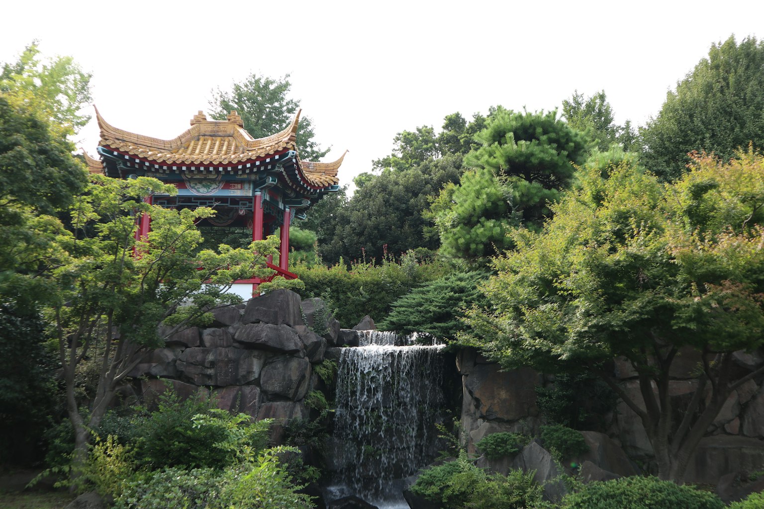 美丽的日本庭园中的传统建筑和小瀑布