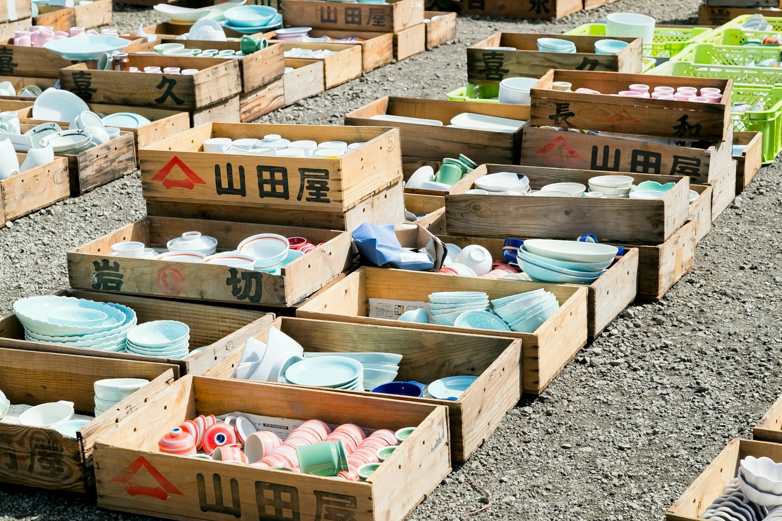 Market scene with ceramic dishes arranged in wooden boxes