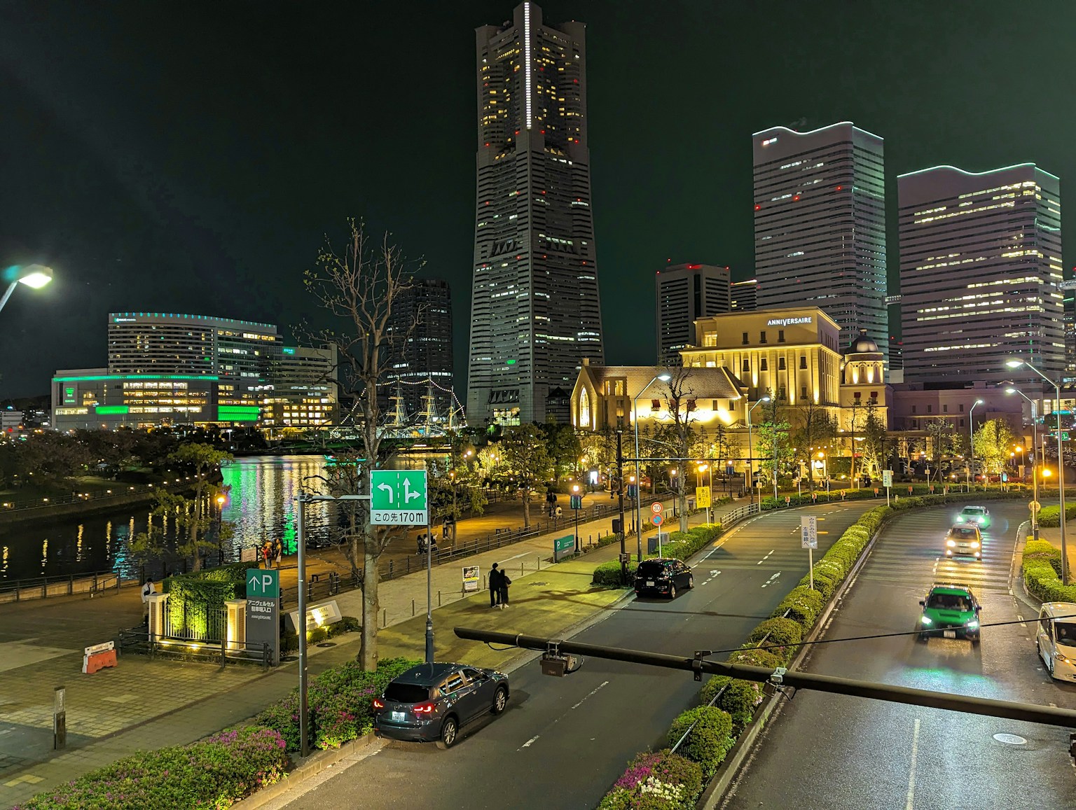ทิวทัศน์เมืองยามค่ำคืน มีตึกสูงและไฟถนน พร้อมรถที่วิ่งผ่าน