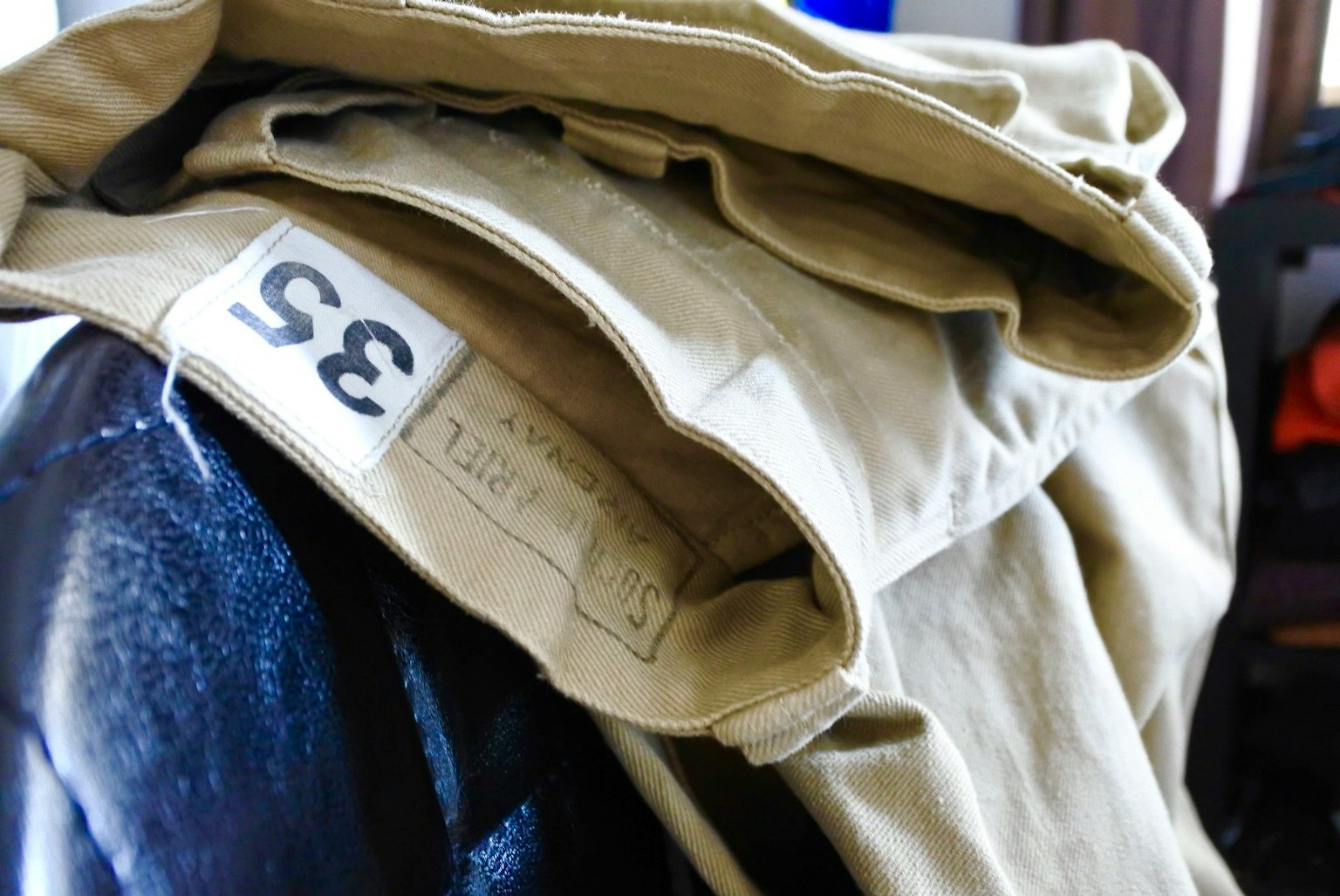 Pantaloni beige piegati su una sedia