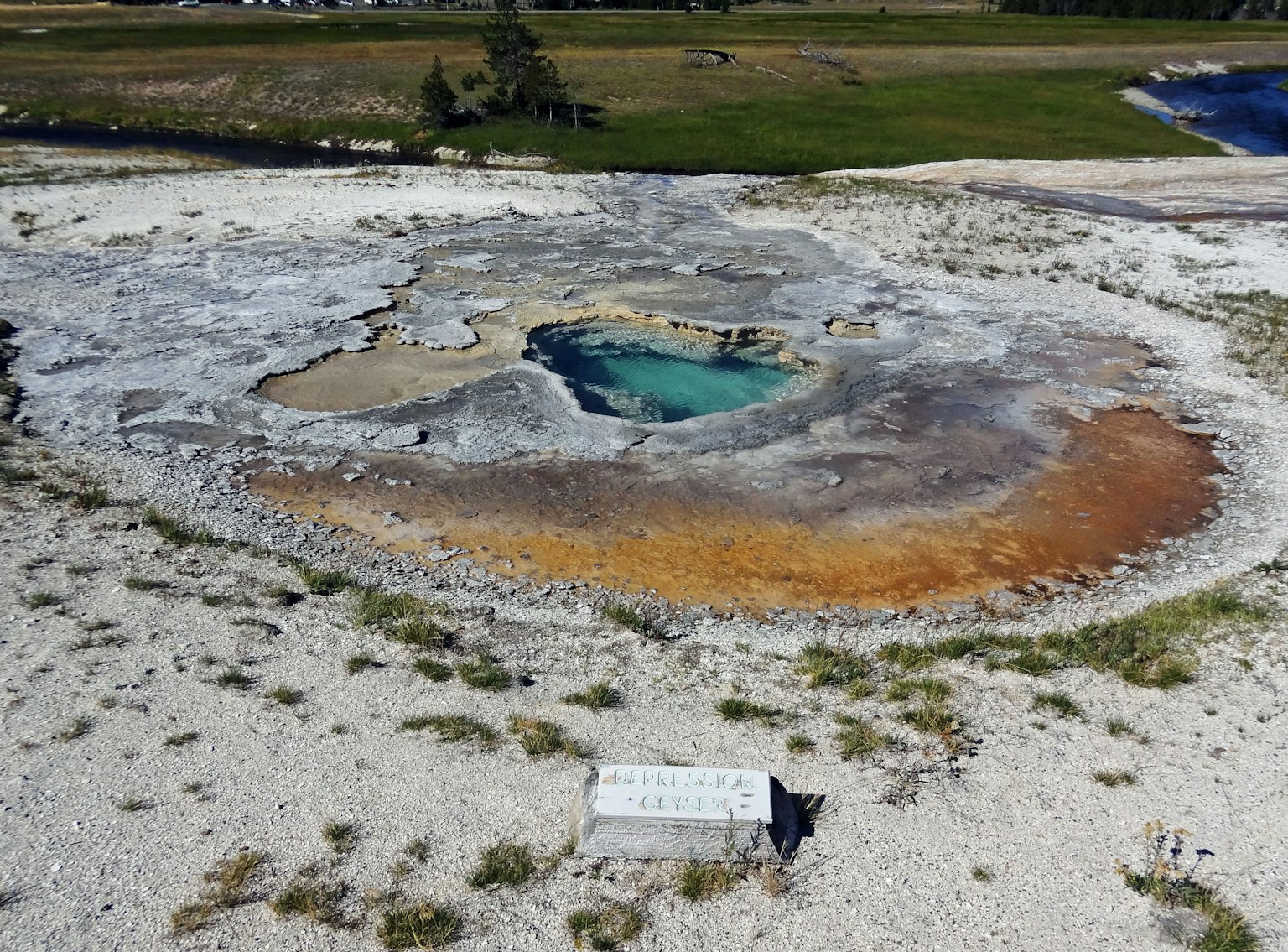 Vista aérea de un manantial caliente de Yellowstone con agua turquesa y depósitos minerales coloridos