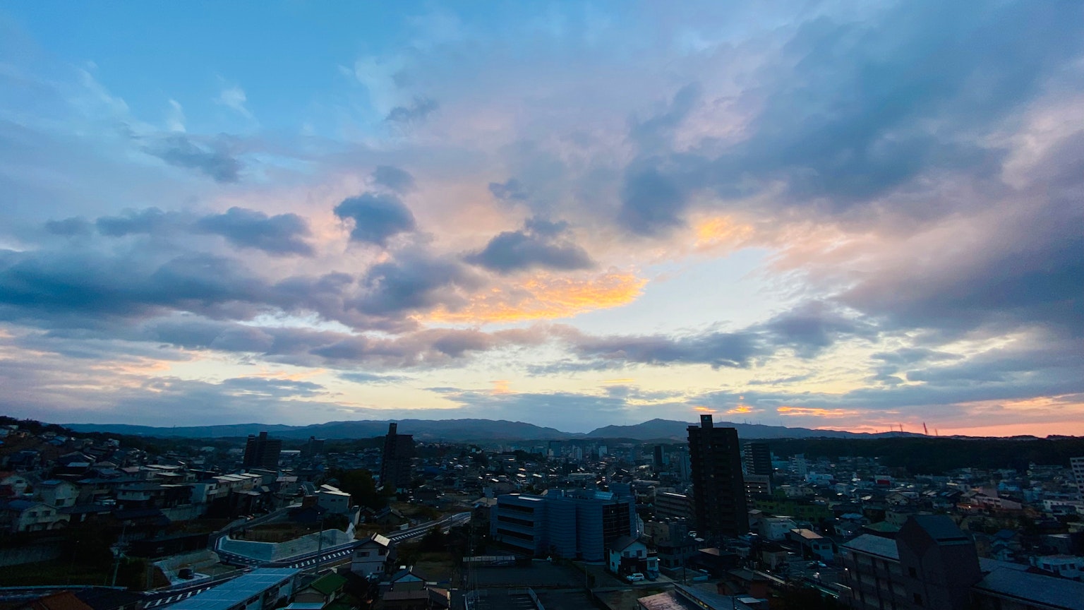 Stadtansicht bei Sonnenuntergang mit bunten Wolken