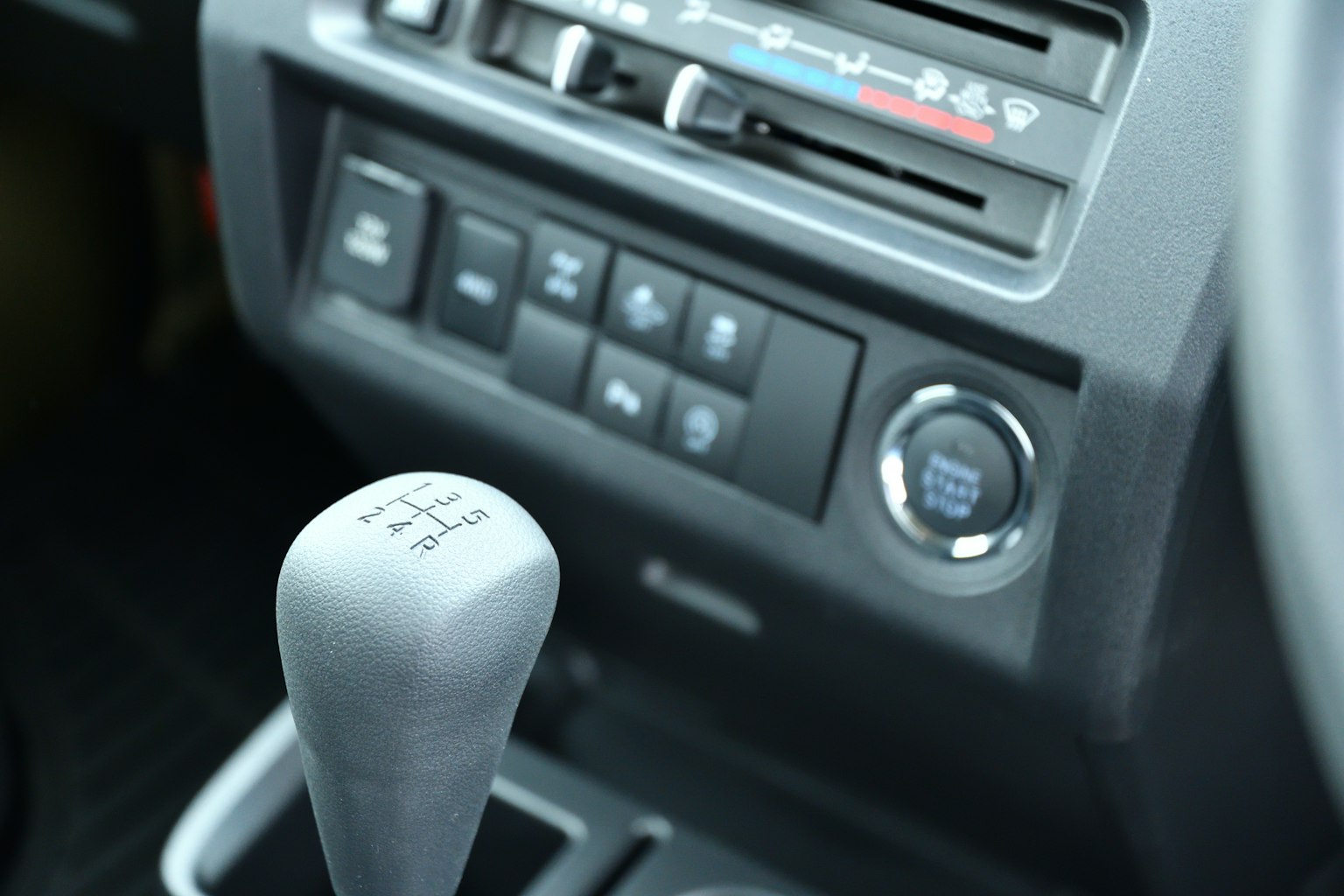 Primer plano de una palanca de cambios y panel de control de un coche