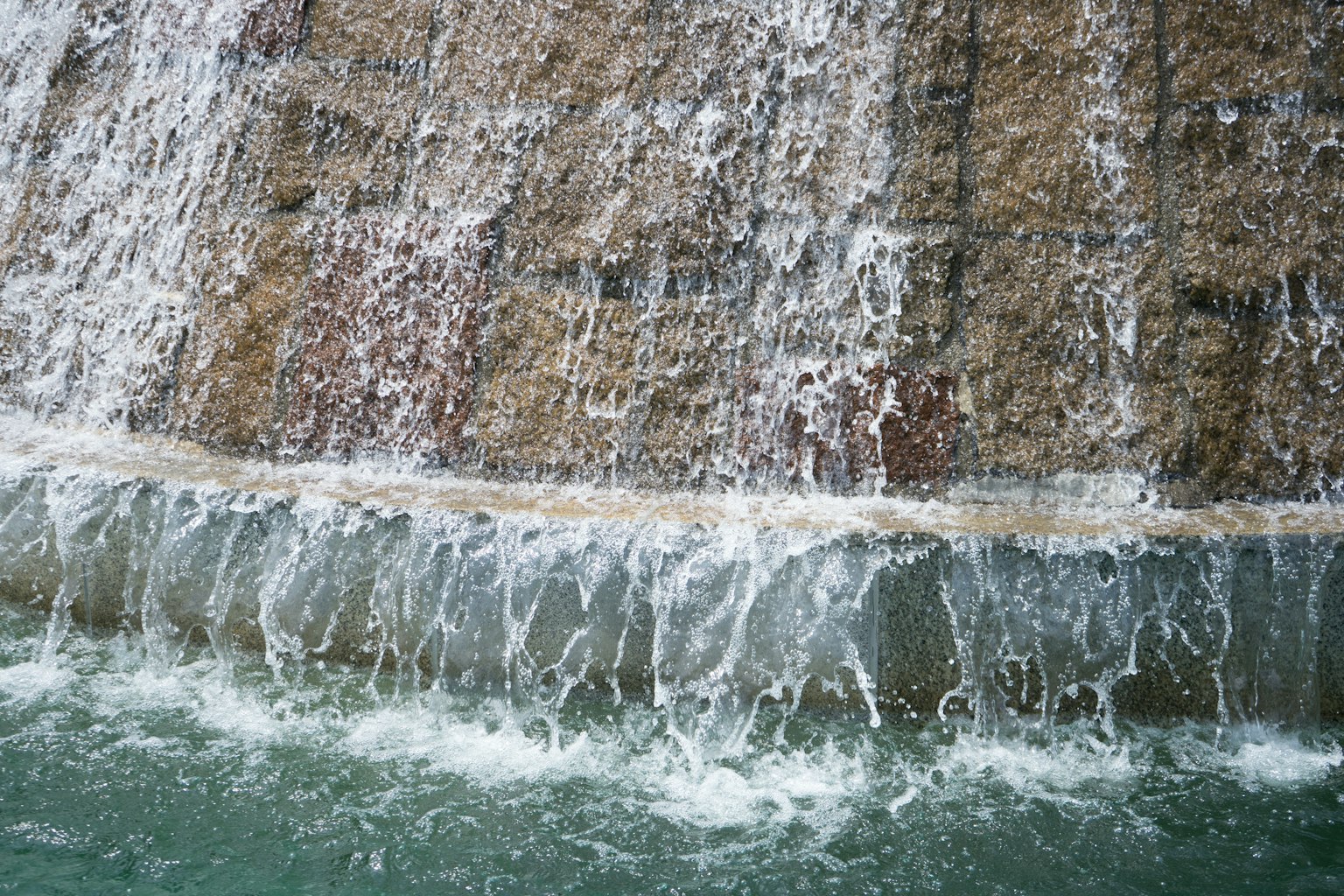 Primo piano di una cascata con acqua che scorre e texture di pietra