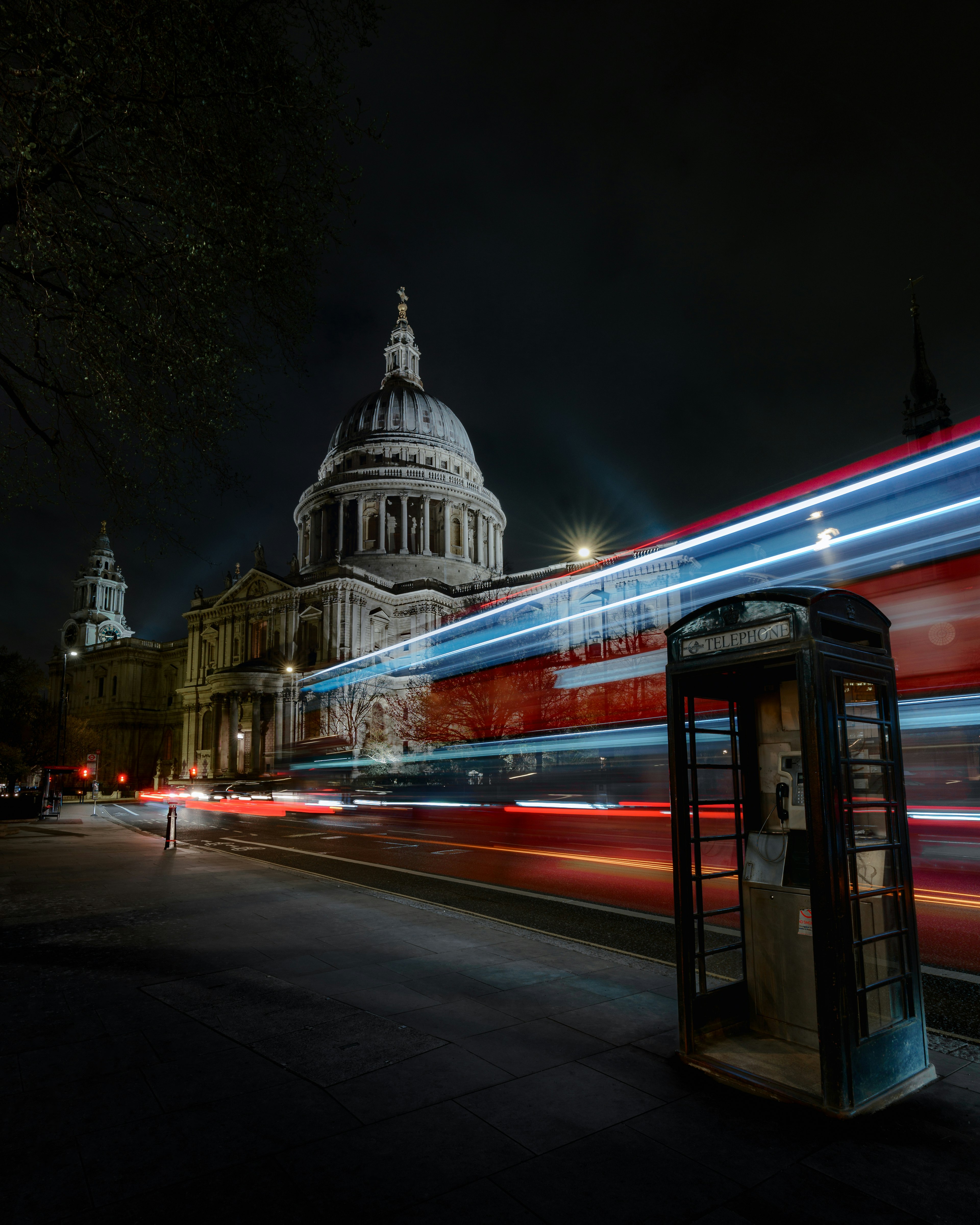 夜のセントポール大聖堂と光の軌跡が流れるロンドンのバス