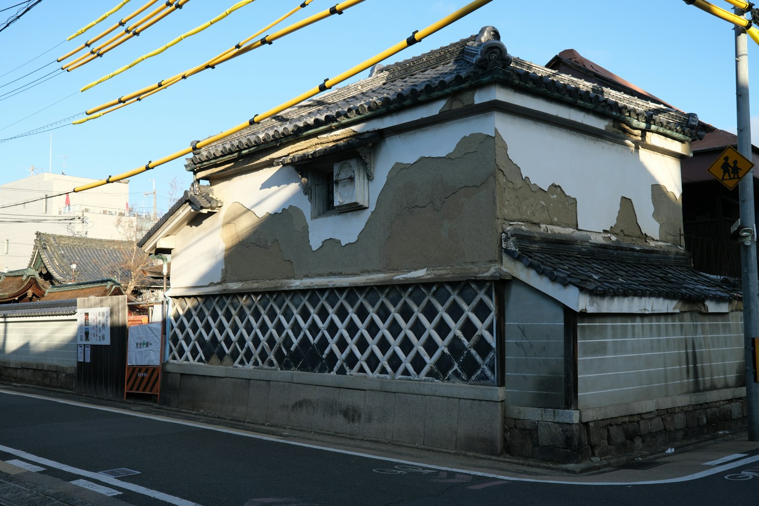 Esterno di un antico edificio giapponese con muri bianchi e grigi e un tetto in tegole distintivo
