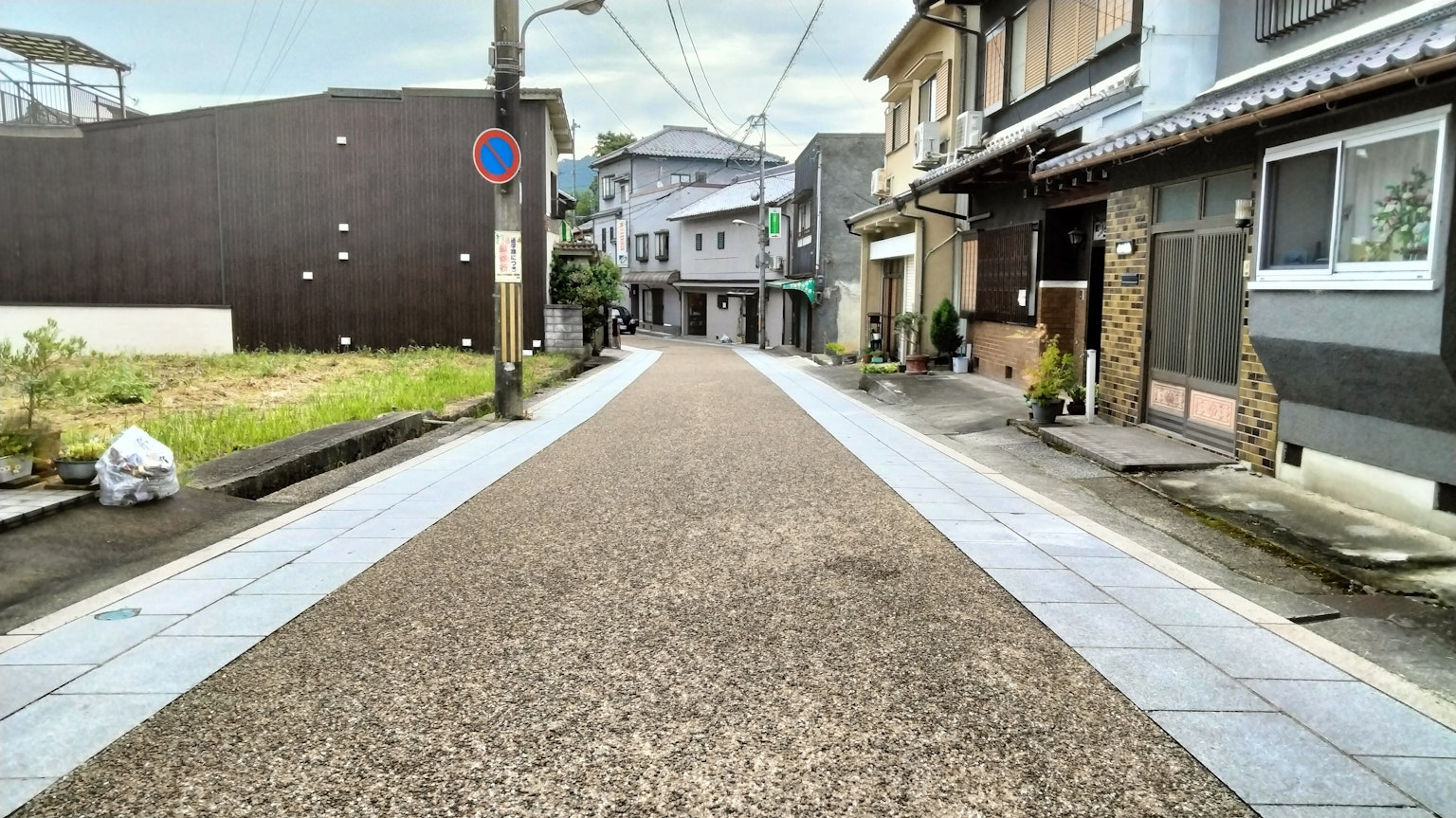 Ruhige Wohnstraße mit Kiesstraße und umliegenden Häusern