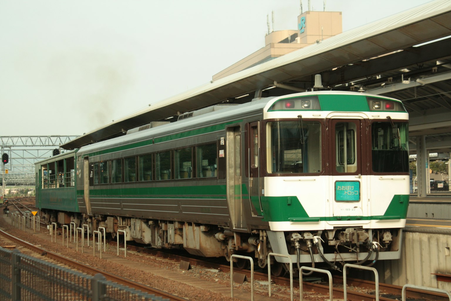รถไฟญี่ปุ่นที่มีแถบสีเขียวจอดอยู่ที่สถานี