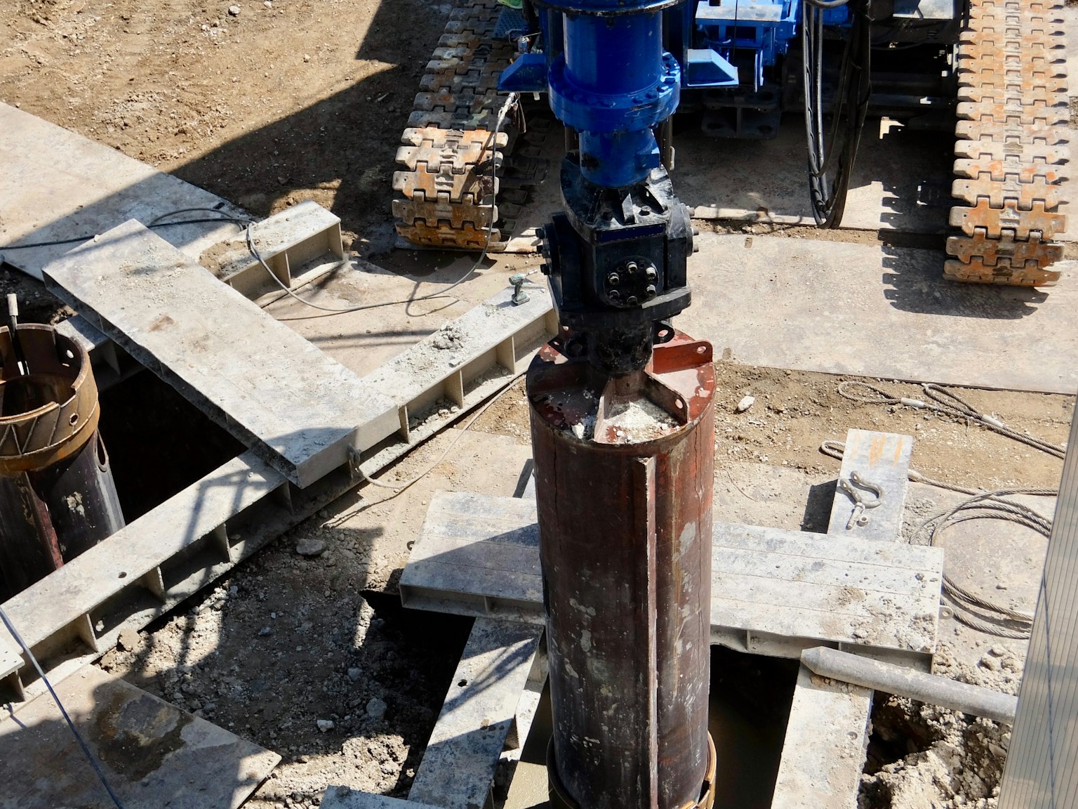 Excavation machinery at a construction site removing a pipe from the ground