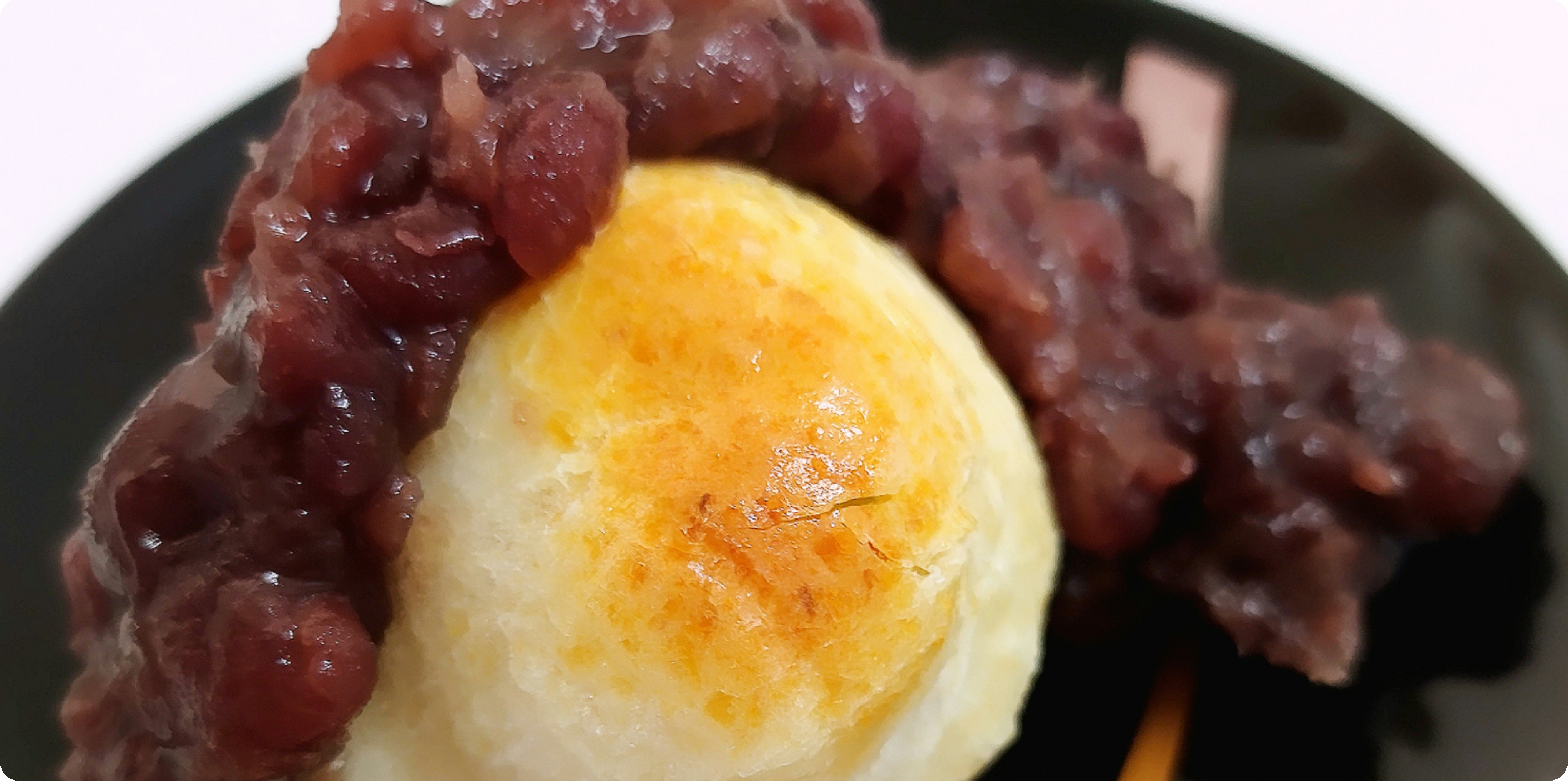 黒い皿に盛られた白玉とあんこの和スイーツ