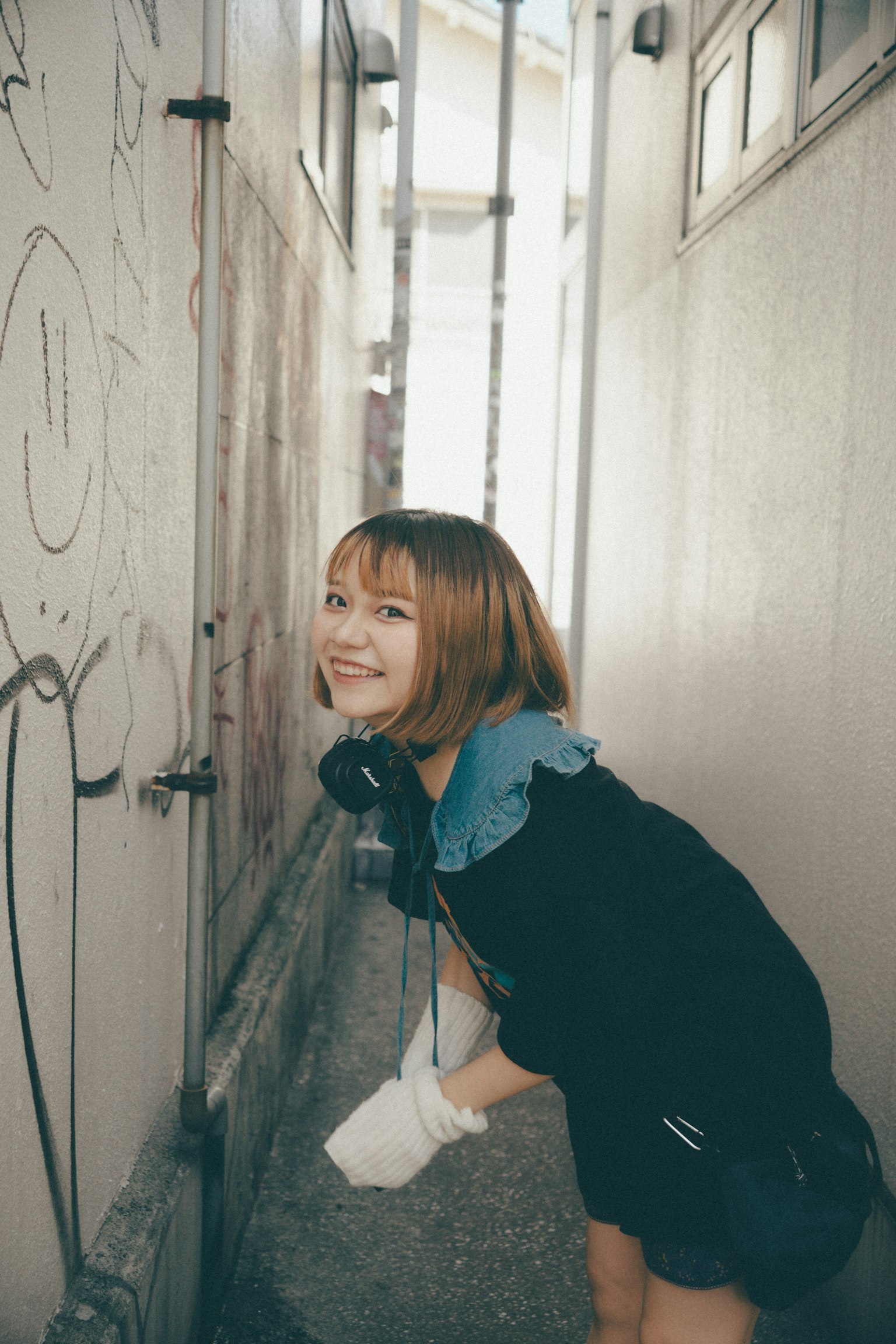 Joven mujer sonriendo en un callejón estrecho