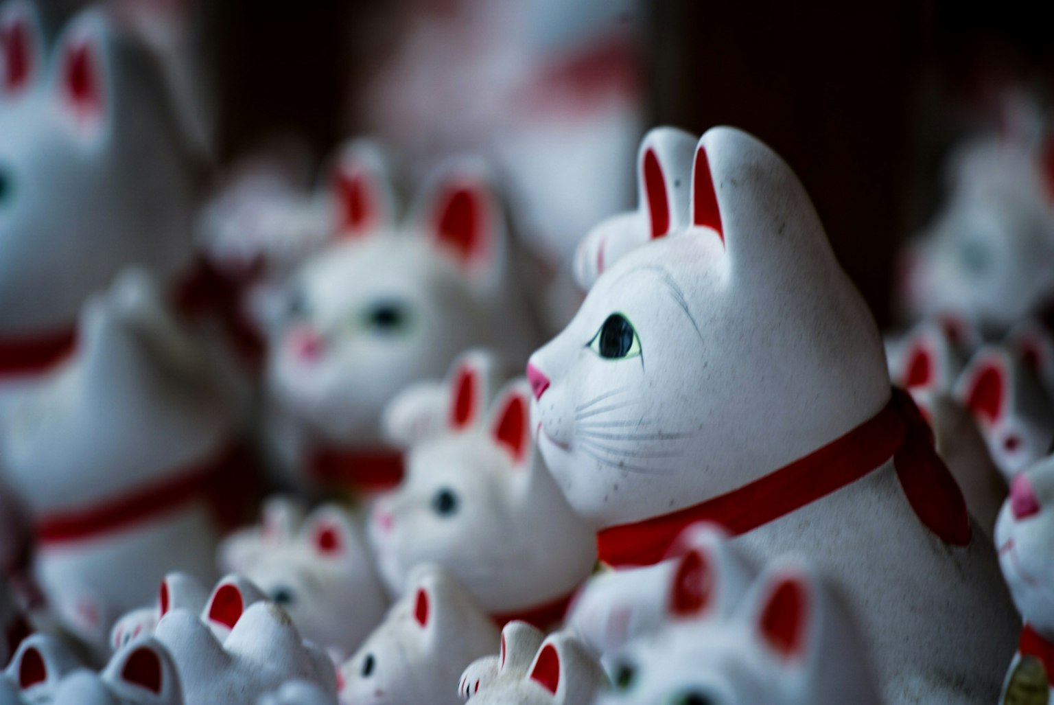 Una escena de figuritas de gatos blancos con collares rojos