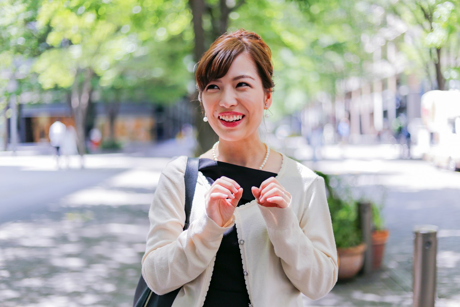 ผู้หญิงยิ้มที่กำลังใช้มือพูดในสวนสาธารณะ