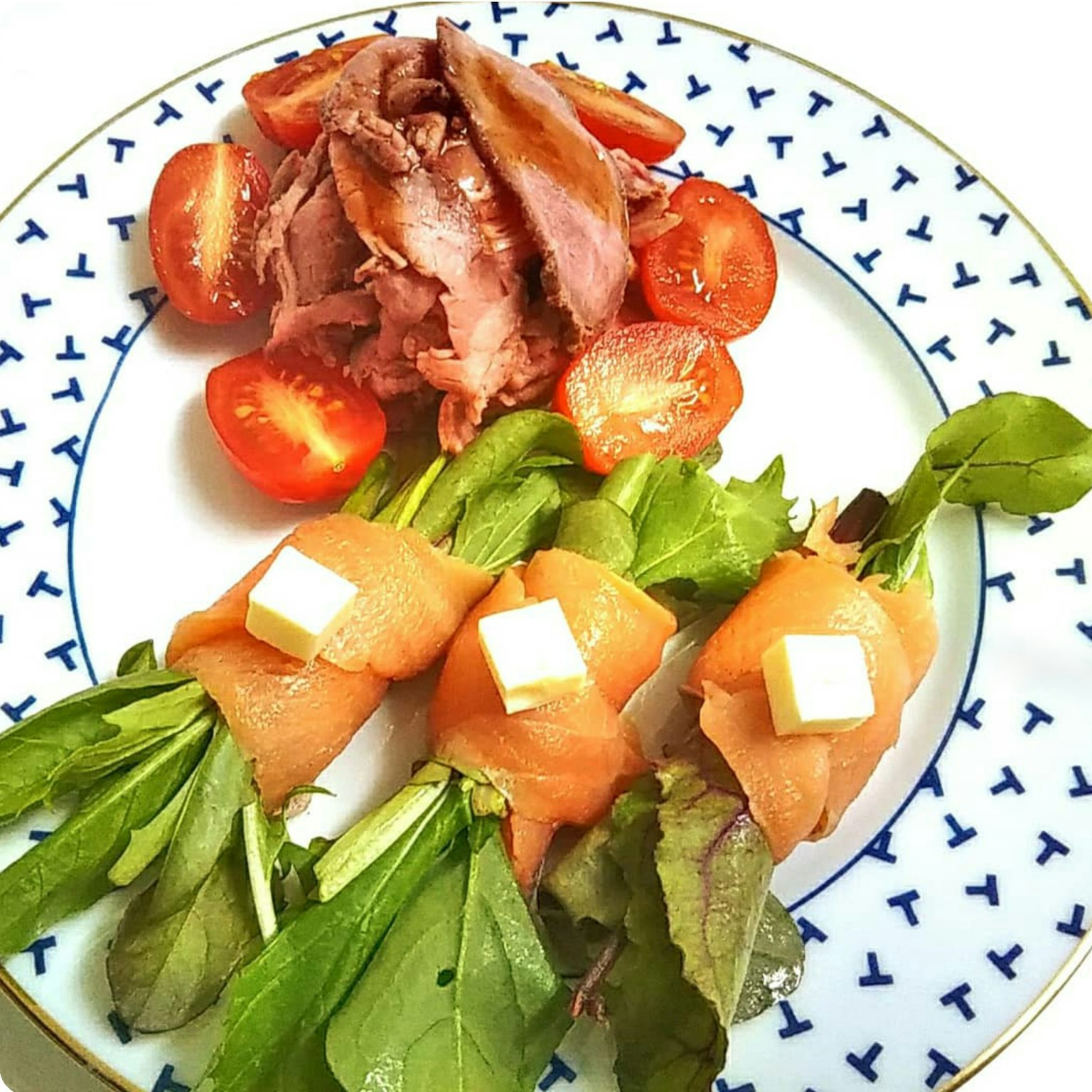 Cuộn cá hồi và bơ được phục vụ với salad và cà chua bi