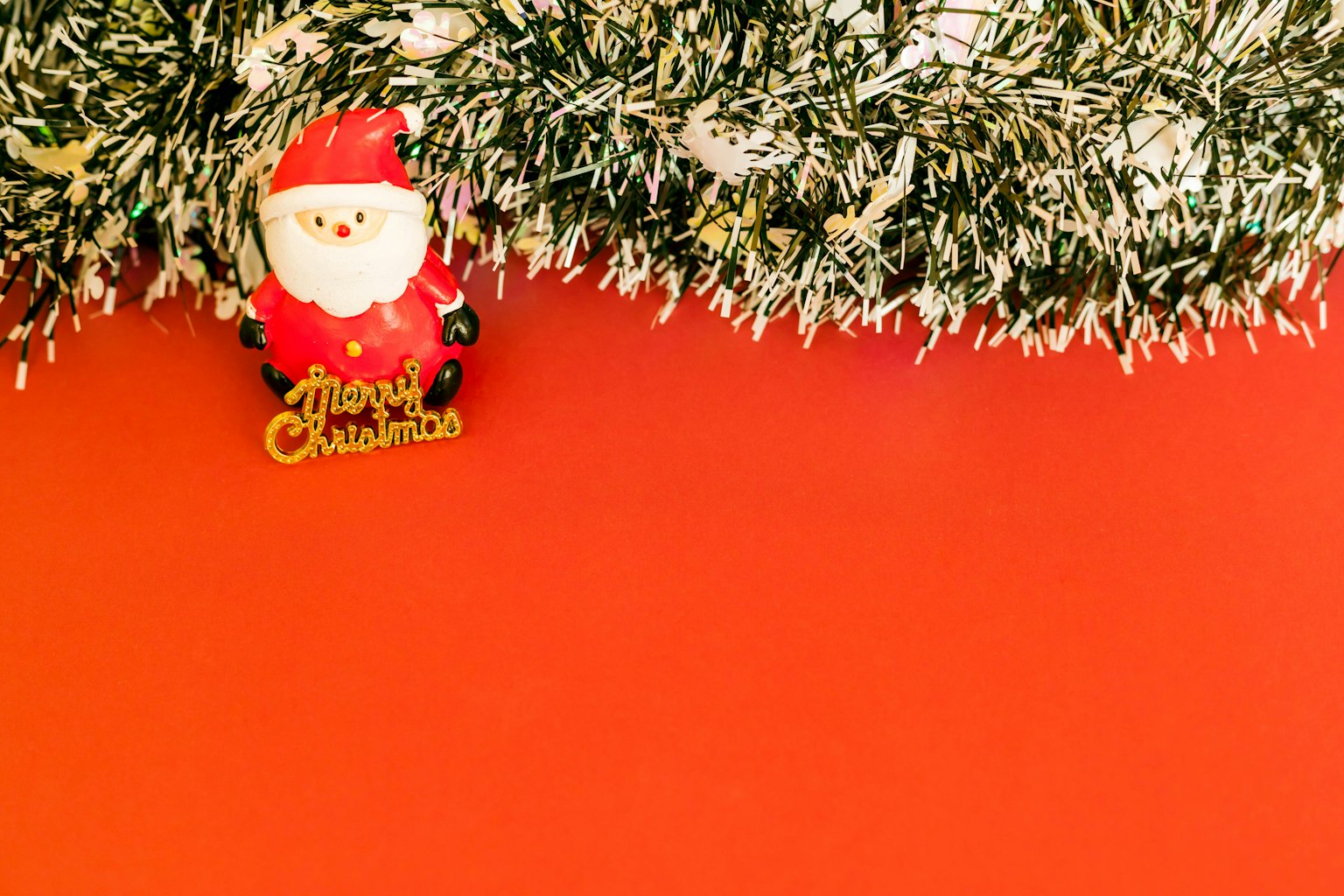 Trang trí ông già Noel và dây trang trí Giáng sinh trên nền đỏ