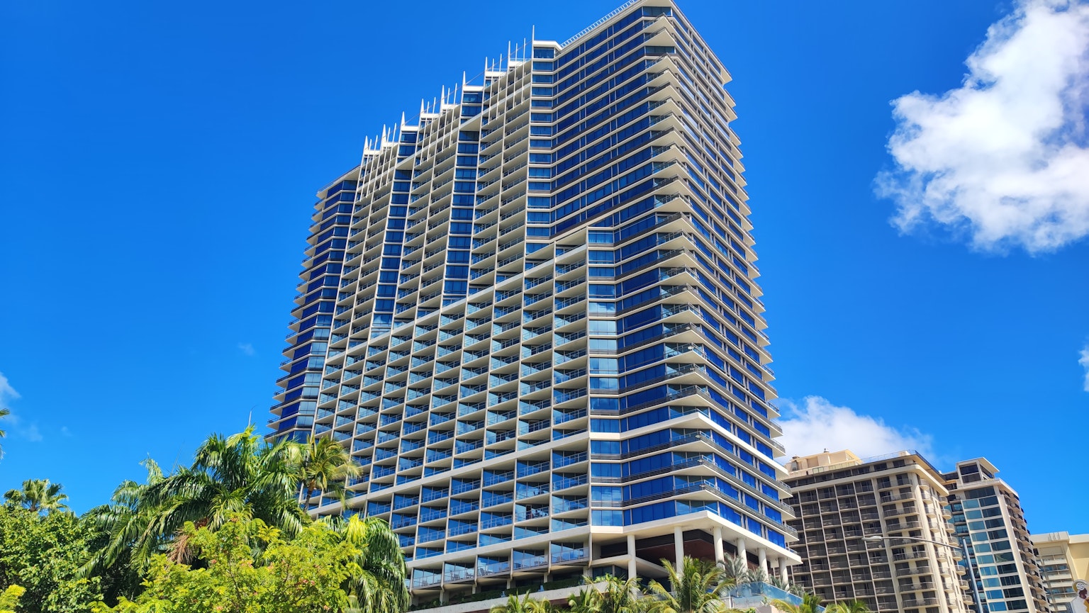 Immeuble de grande hauteur sous un ciel bleu avec des arbres verts