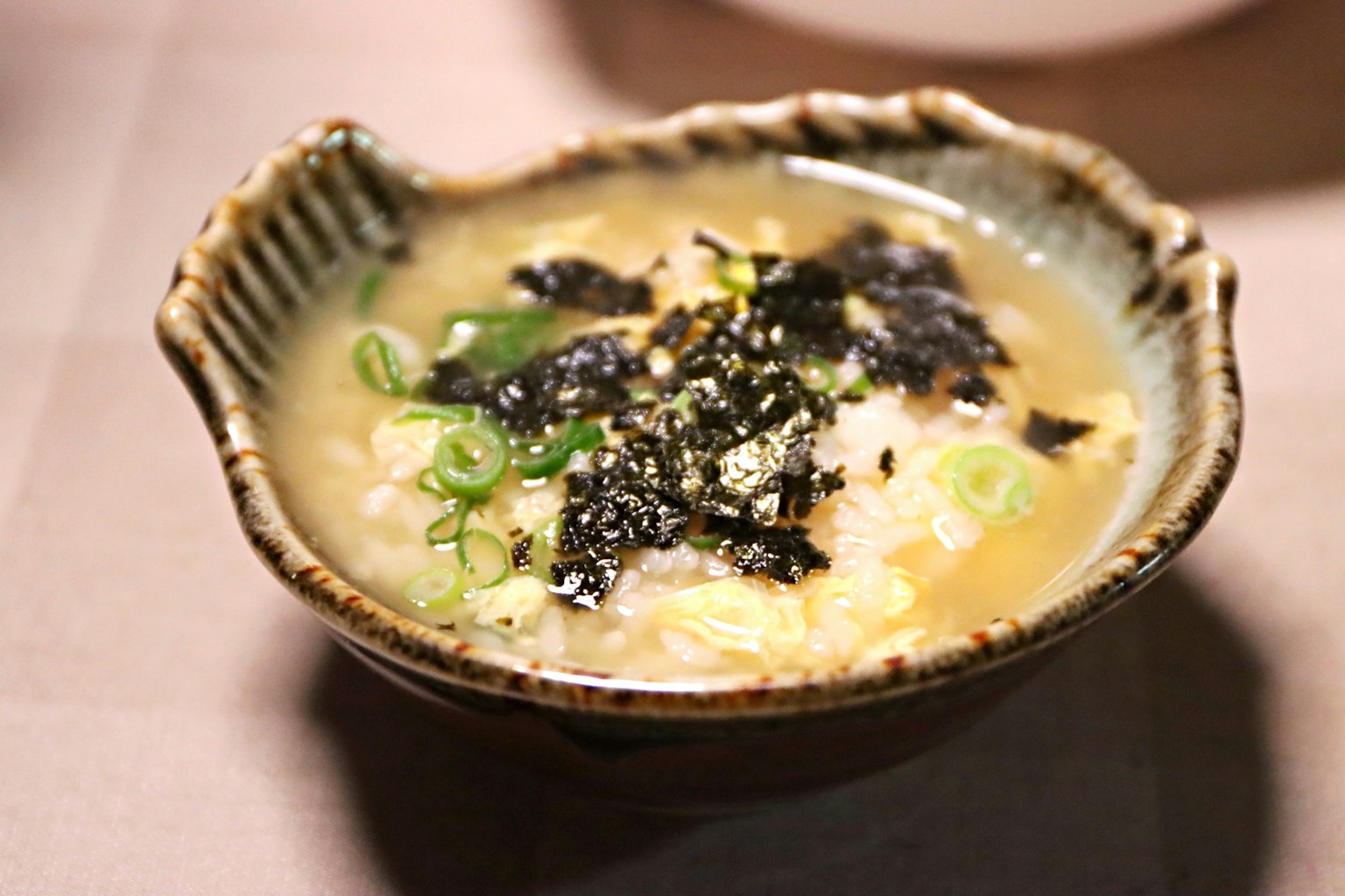 Tazón de gachas calientes cubierto con alga y cebollino