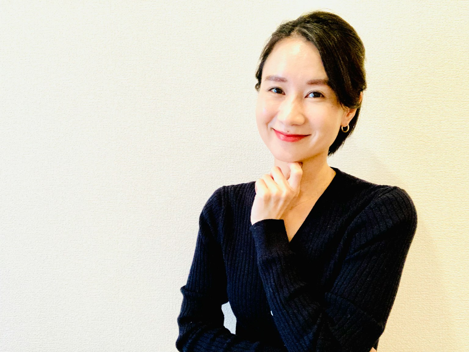 一位微笑的女性用手托著下巴思考的姿勢