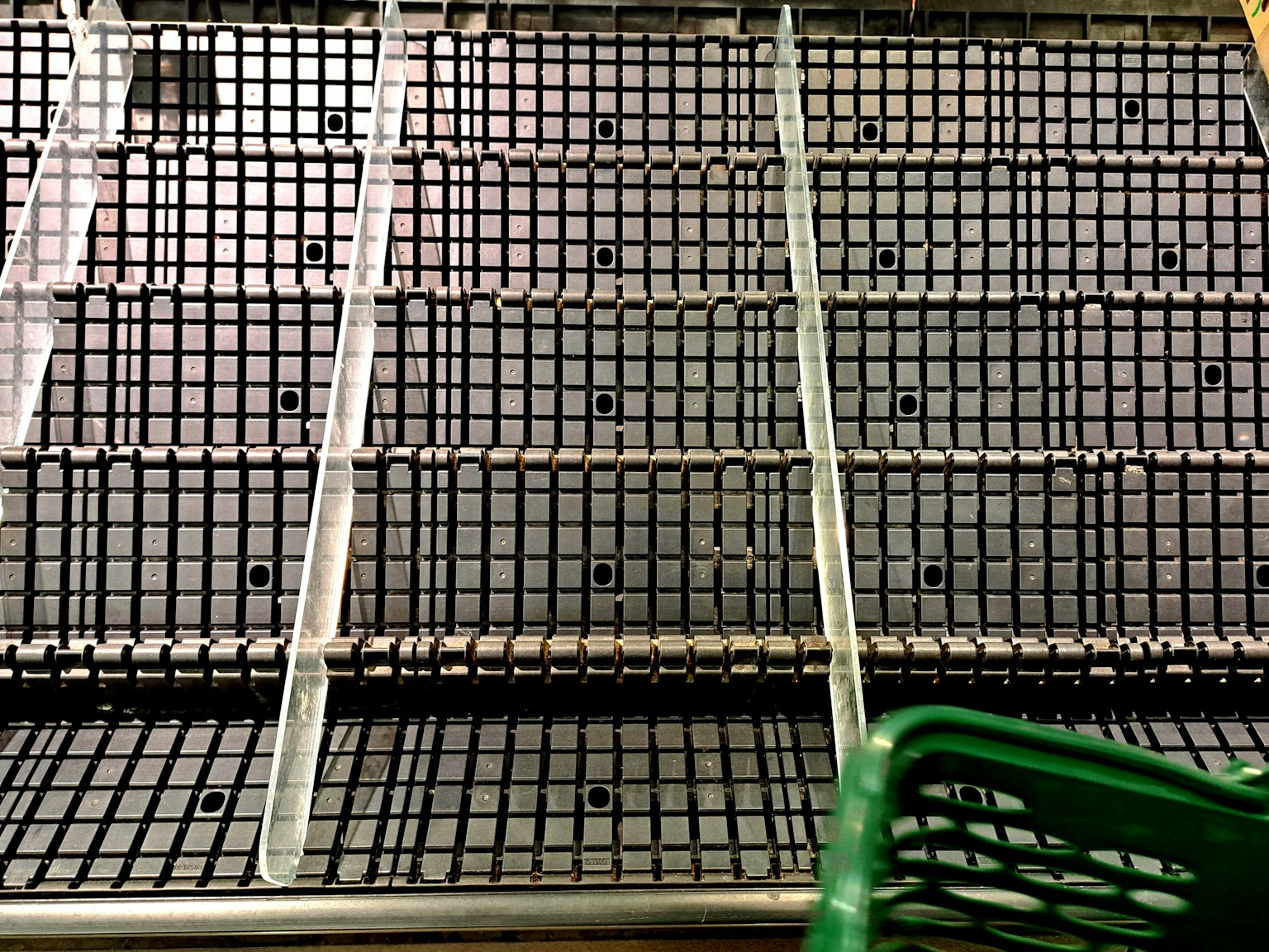 Bild von leeren Regalen mit einem grünen Einkaufswagen