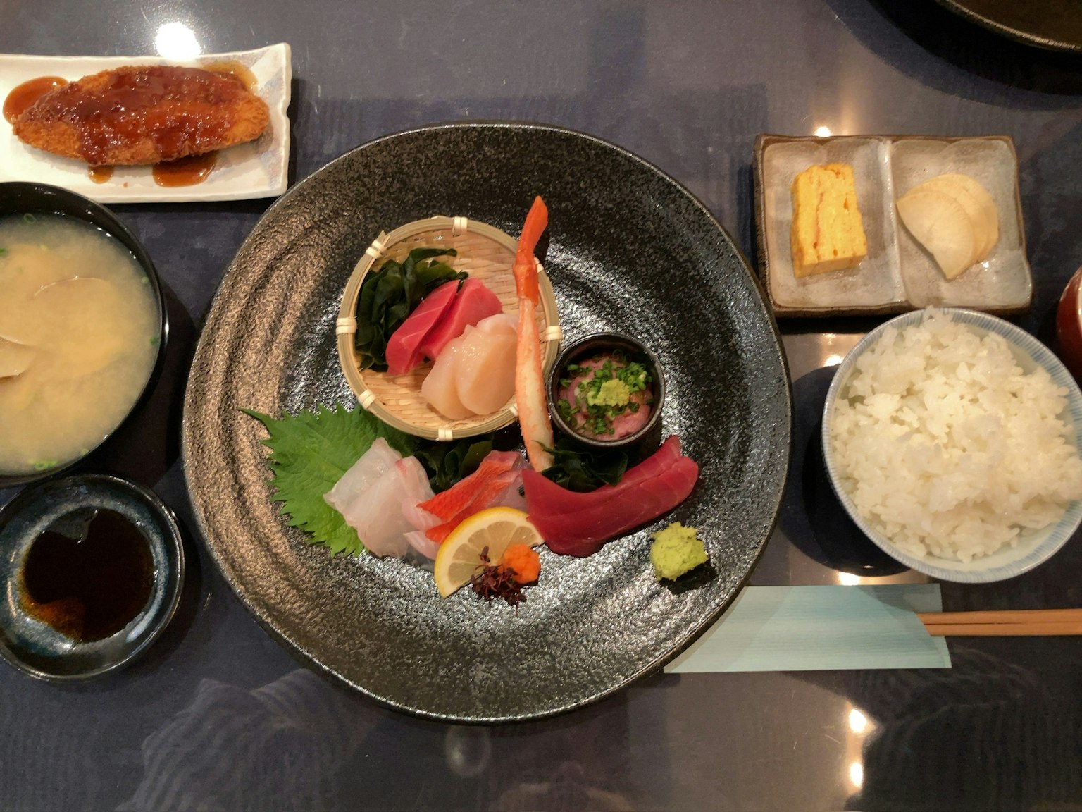 Schönes Plattenspieler mit Sushi und Sashimi, einschließlich Miso-Suppe, weißem Reis und Tamagoyaki-Dessert