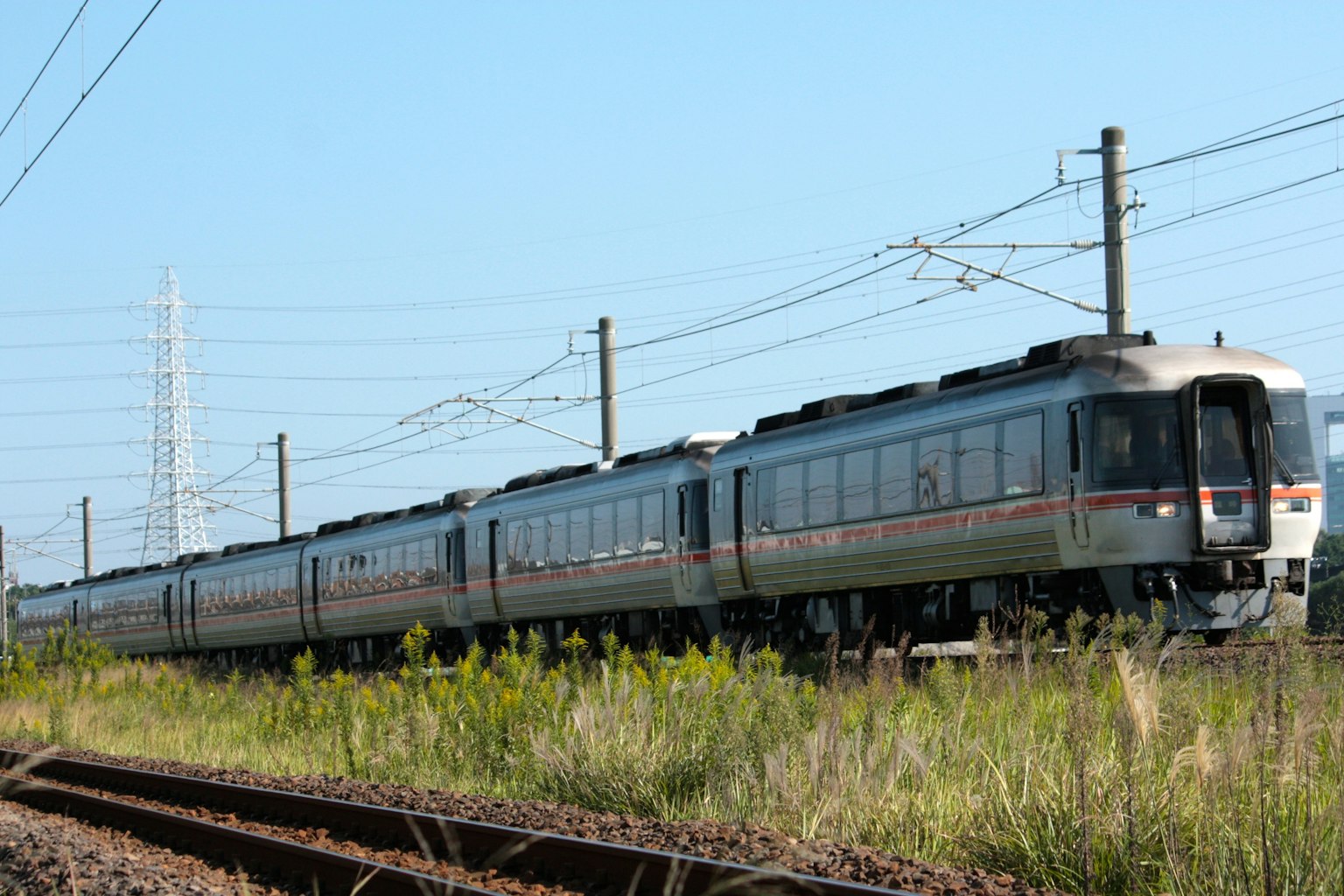 รถไฟสีเงินแล่นใต้ท้องฟ้าสีฟ้า