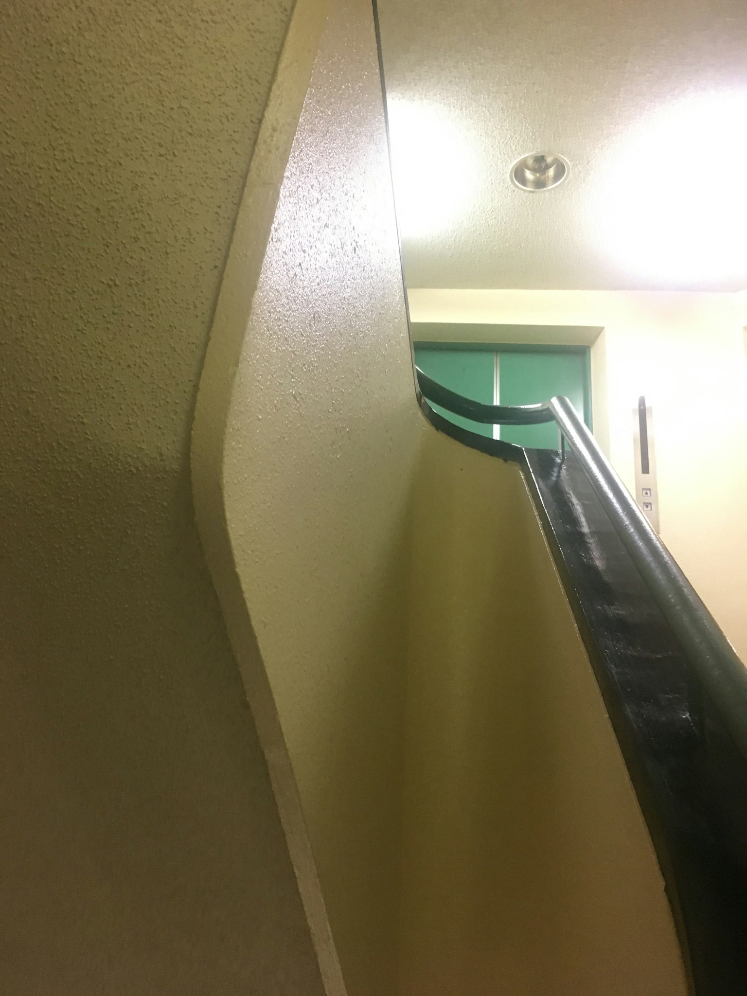 Vue intérieure avec escalier courbe et porte verte