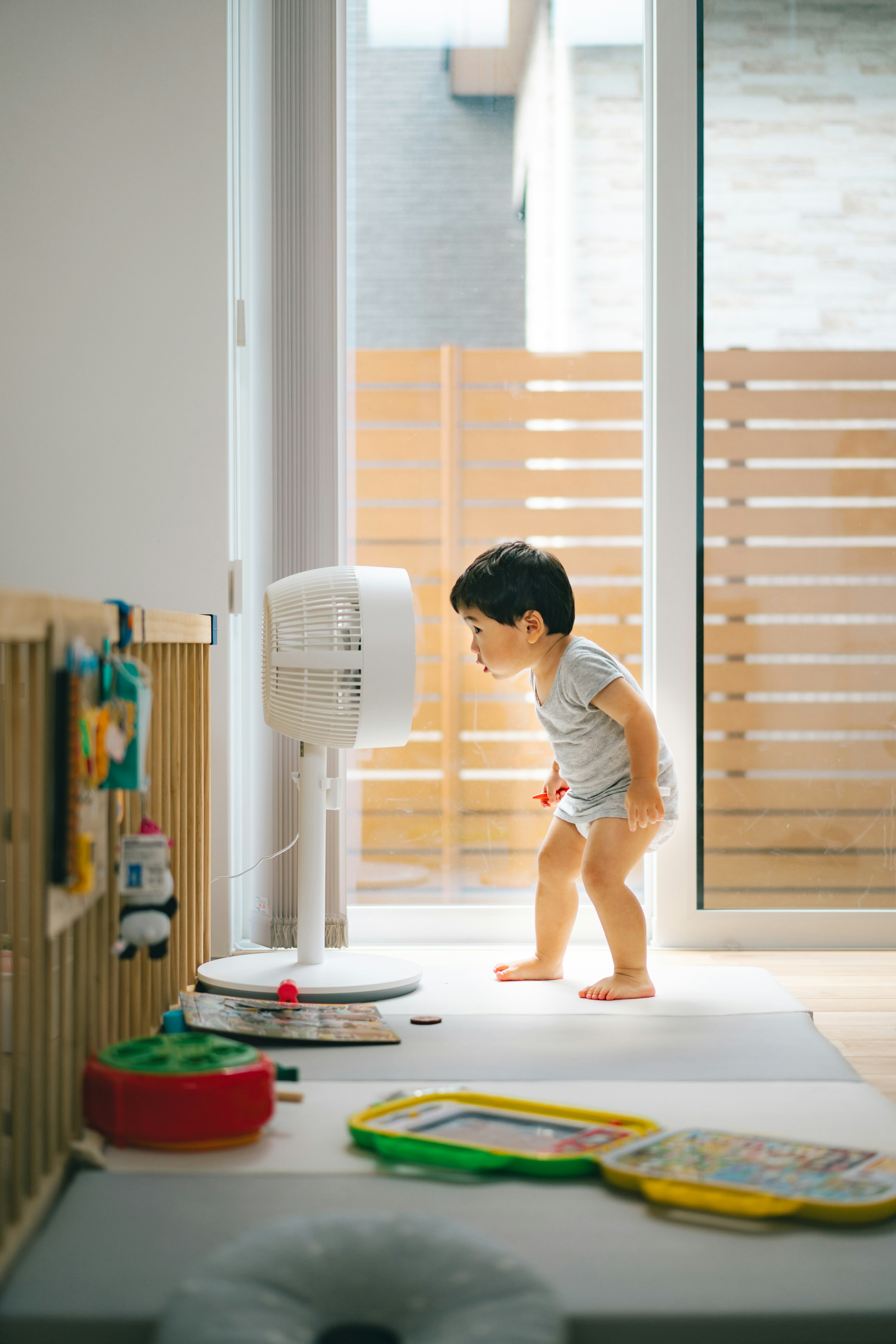 扇風機の前で立って遊ぶ2歳の男の子の初めての遭遇
