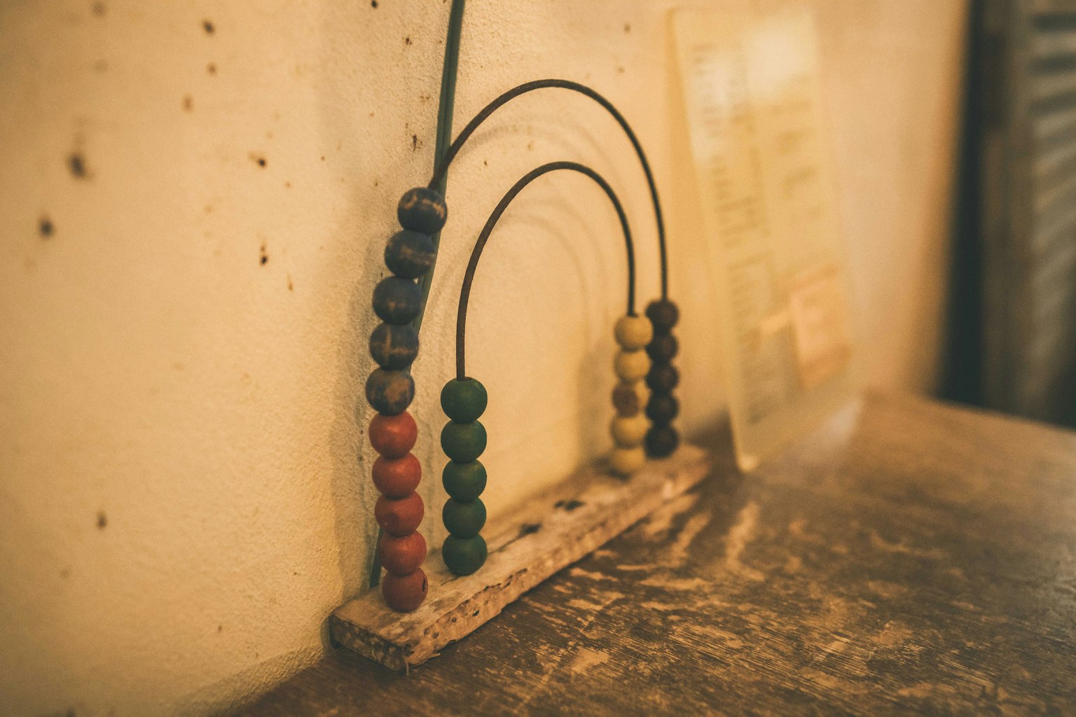 Perline colorate disposte su un abaco poggiato su una base di legno