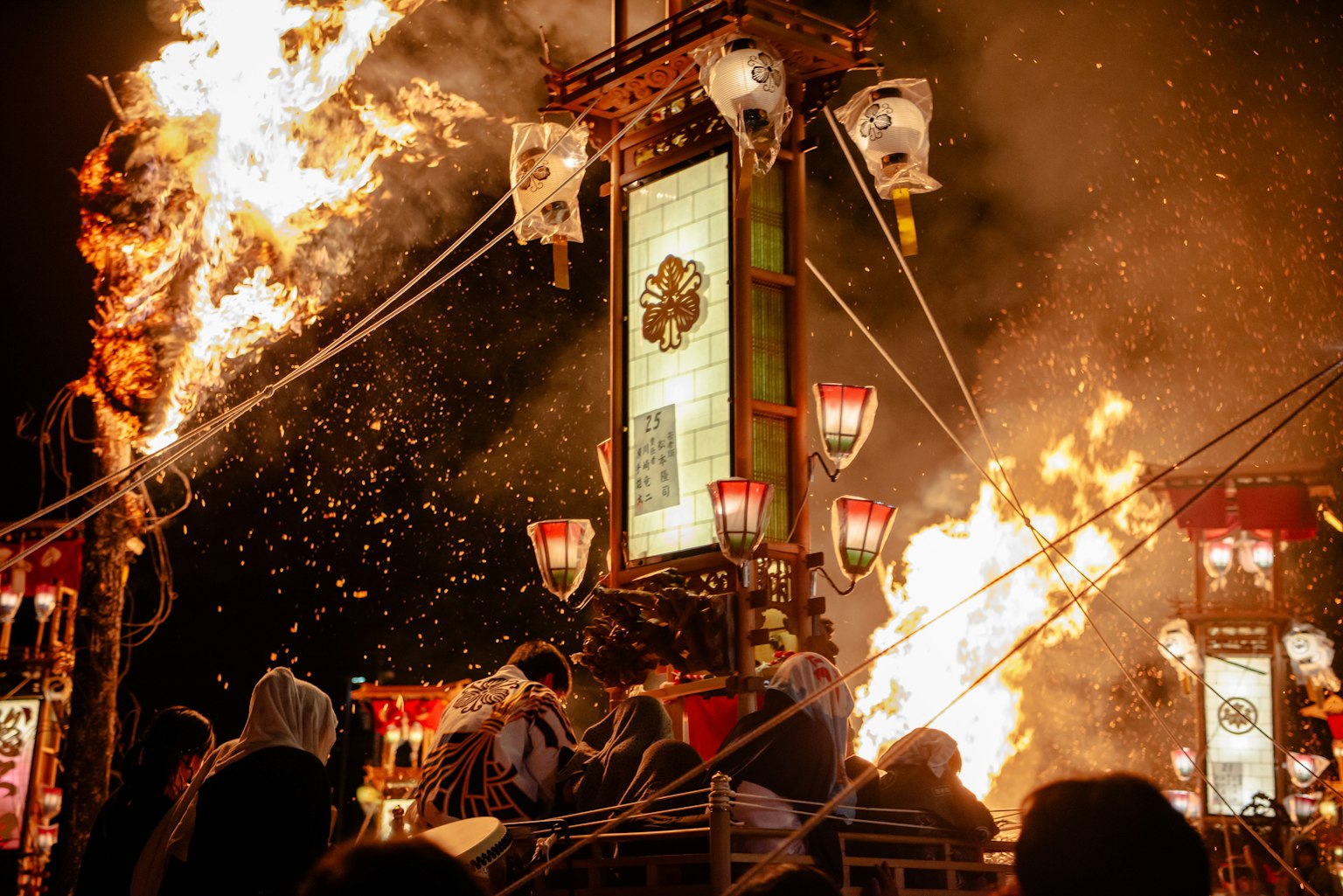 人们在火祭中聚集，伴随着火焰和灯笼