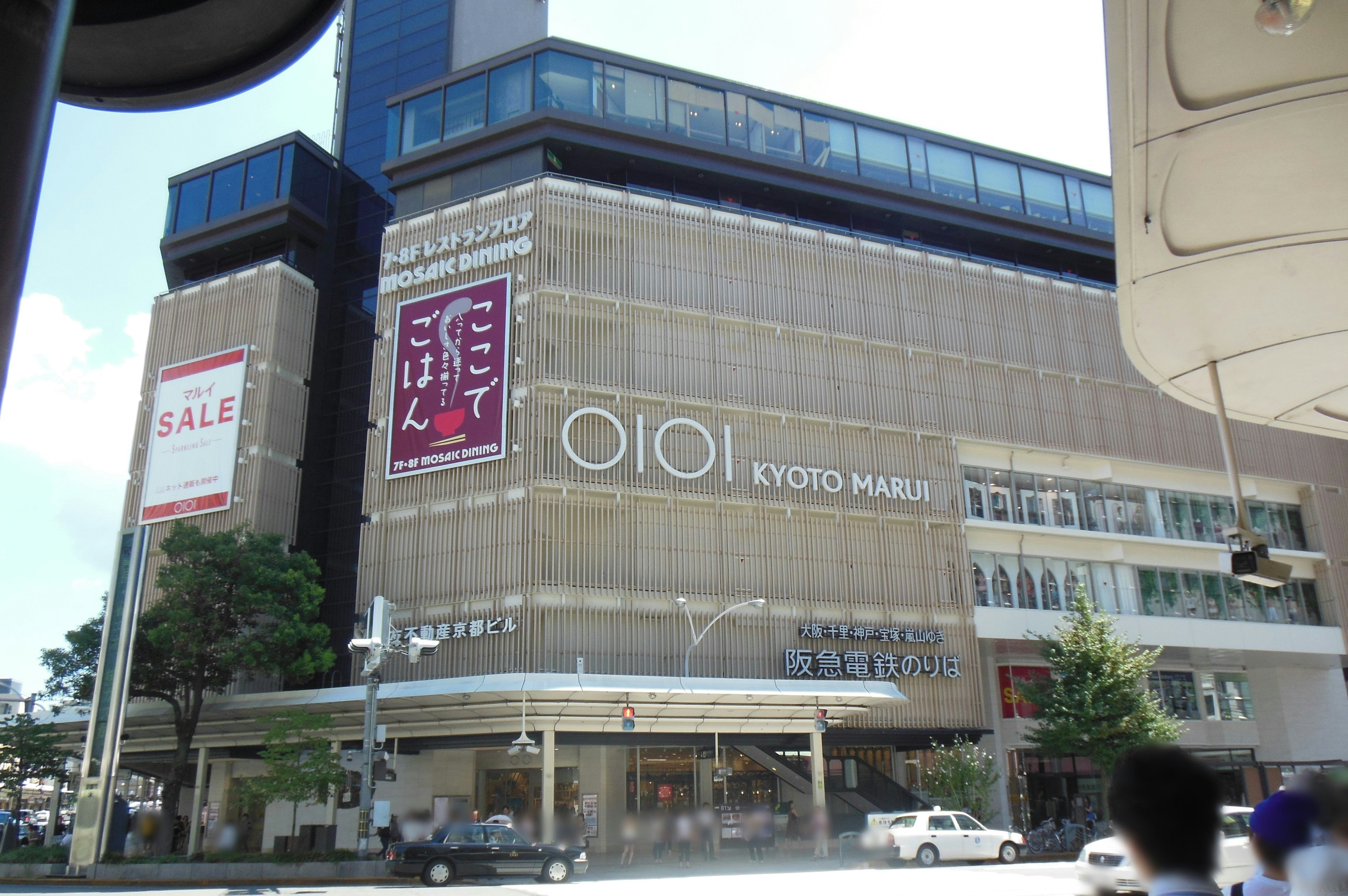 Tampilan eksterior gedung komersial dengan papan “OI OI KYOTO MARU”