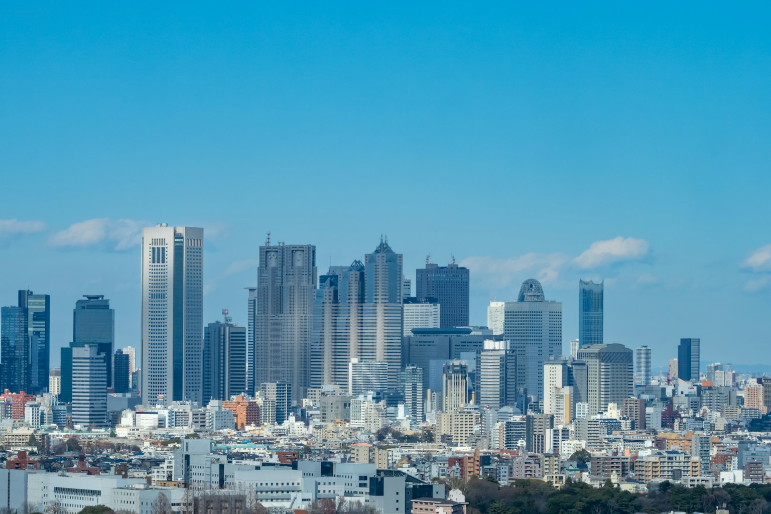 Garis langit Tokyo dengan gedung pencakar langit modern dan langit biru cerah